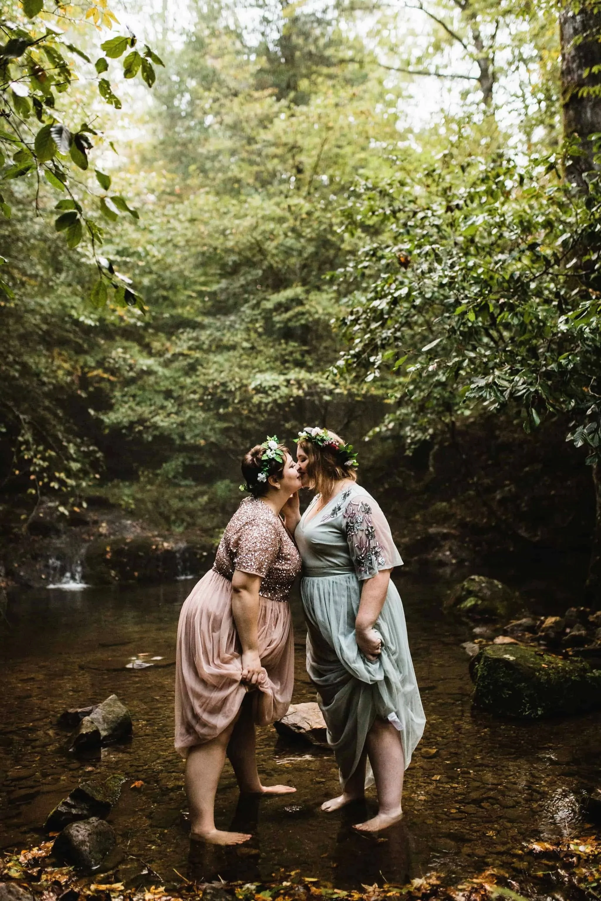 A couple kisses while standing in a small pond together