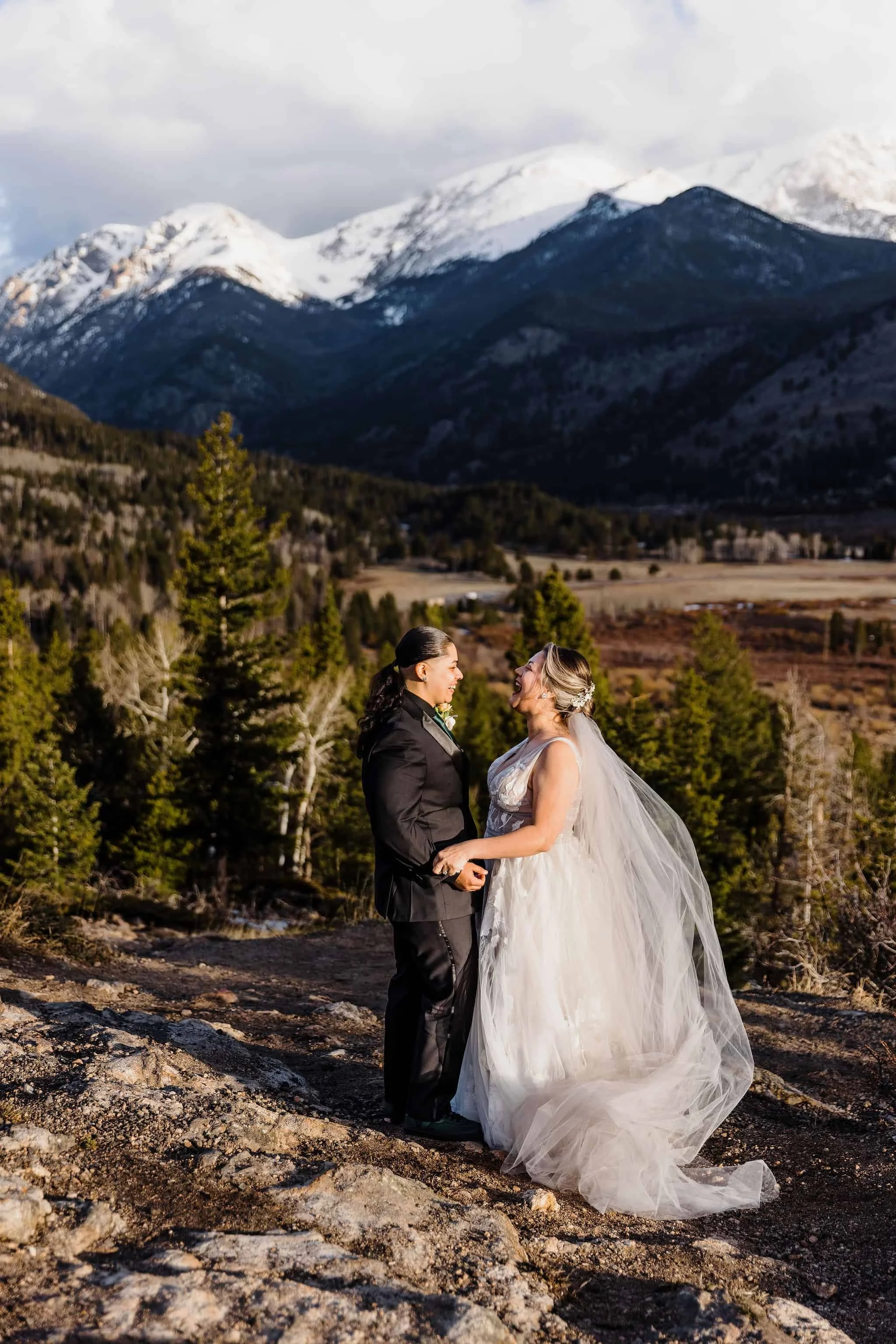 A couple holds hands in the mountains