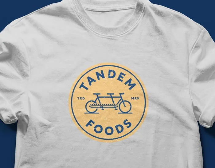 Gold and blue emblem on a white t-shirt.