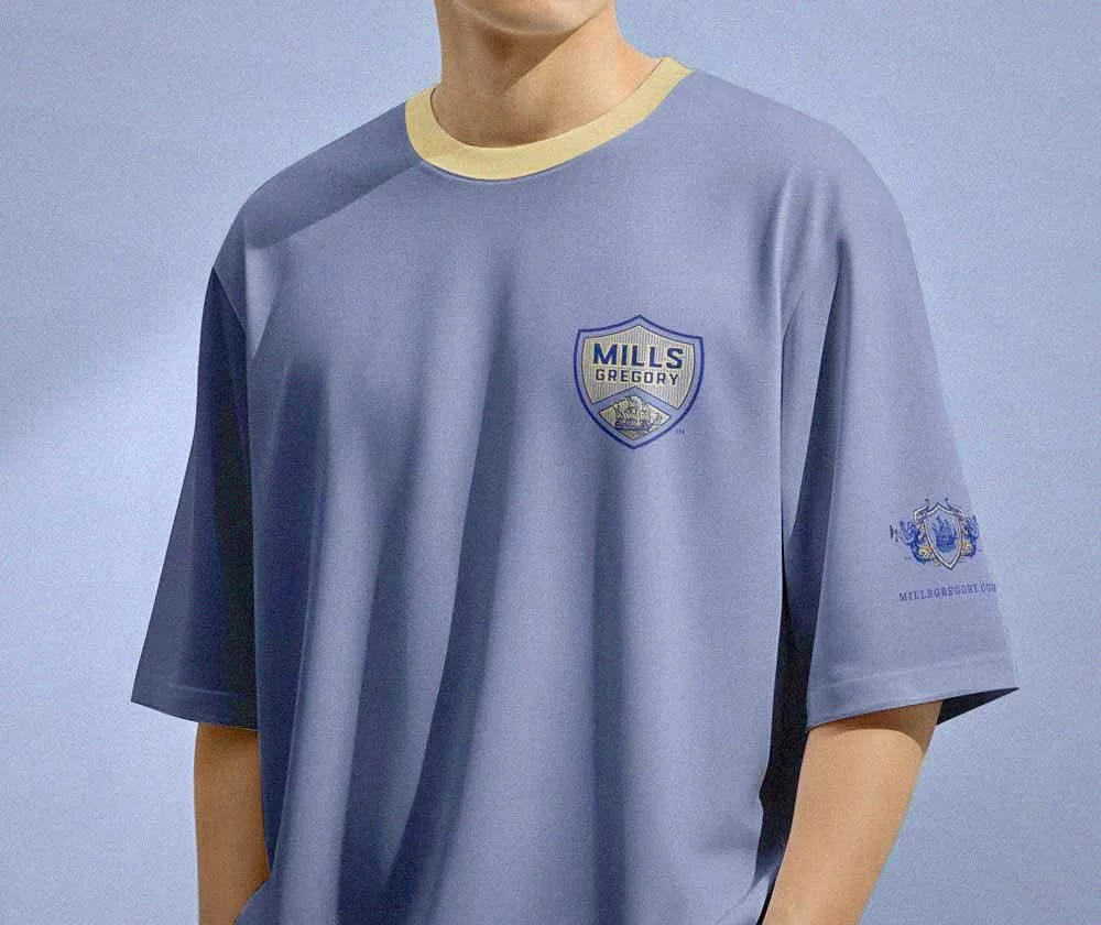 Front of man’s golf shirt with gold and blue shield logo and gold collar trim.