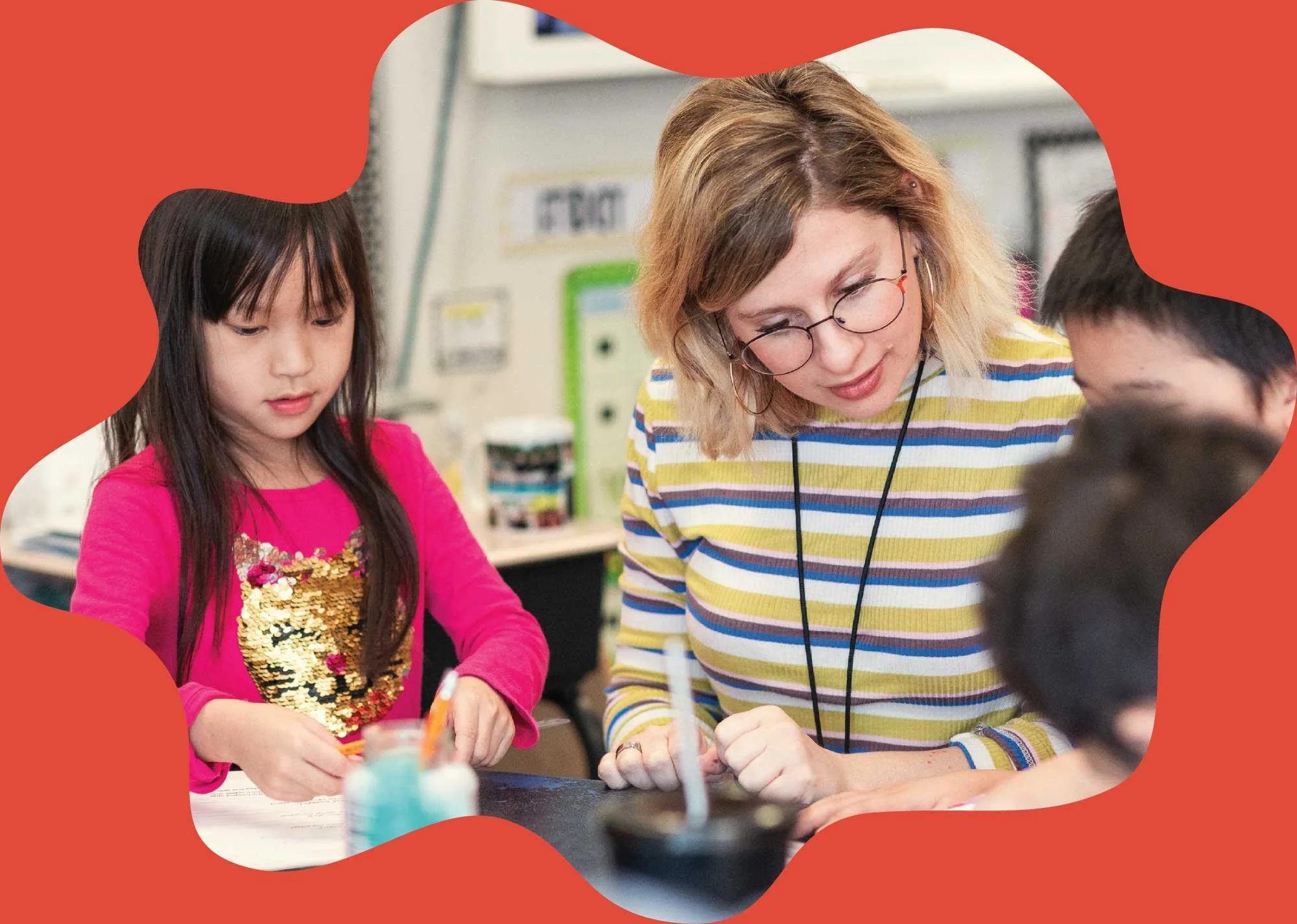 Teacher working with three students in a classroom.
