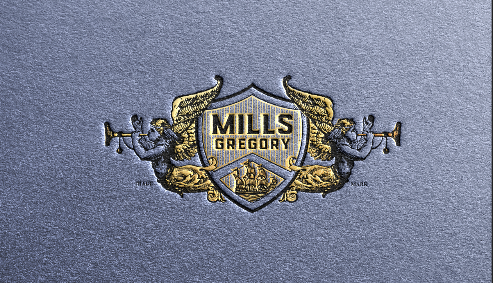 Black and gold embossed Mills-gregory herald logo on toothy blue paper.