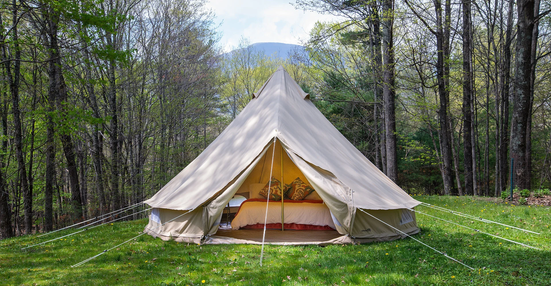All-weather canvas bell tent, Cozy glamping set-up with real mattresses, bedding, and rugs