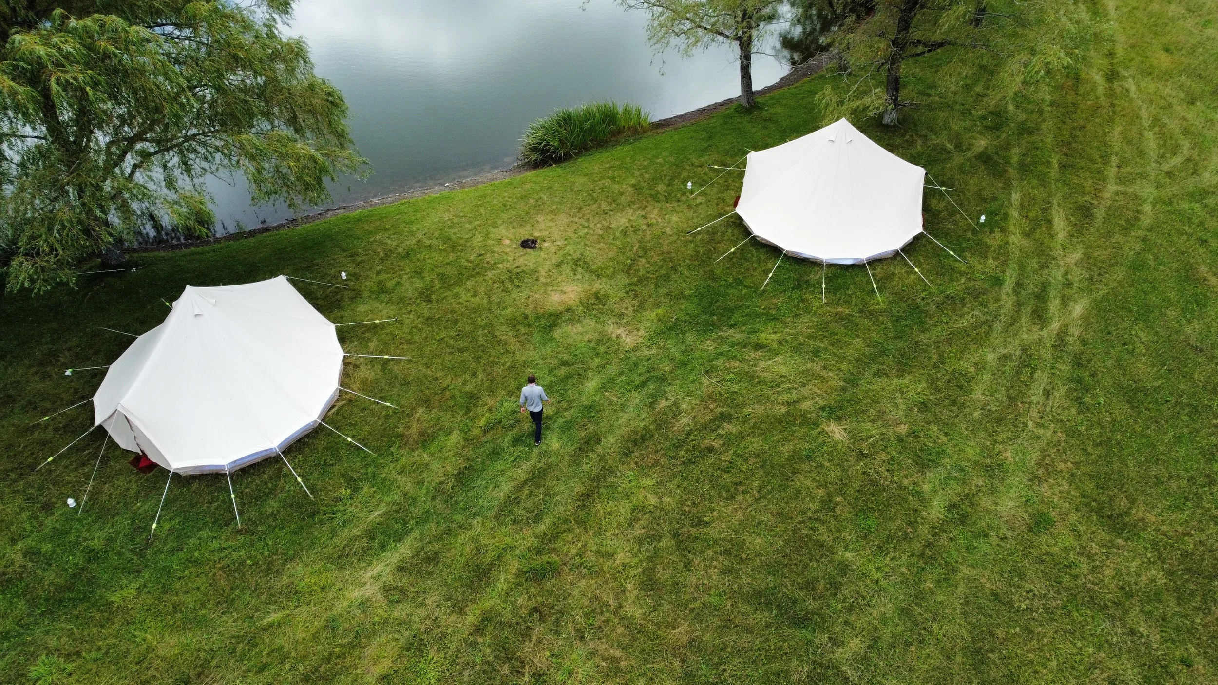 Aerial Glampstar tent set-up by a pond