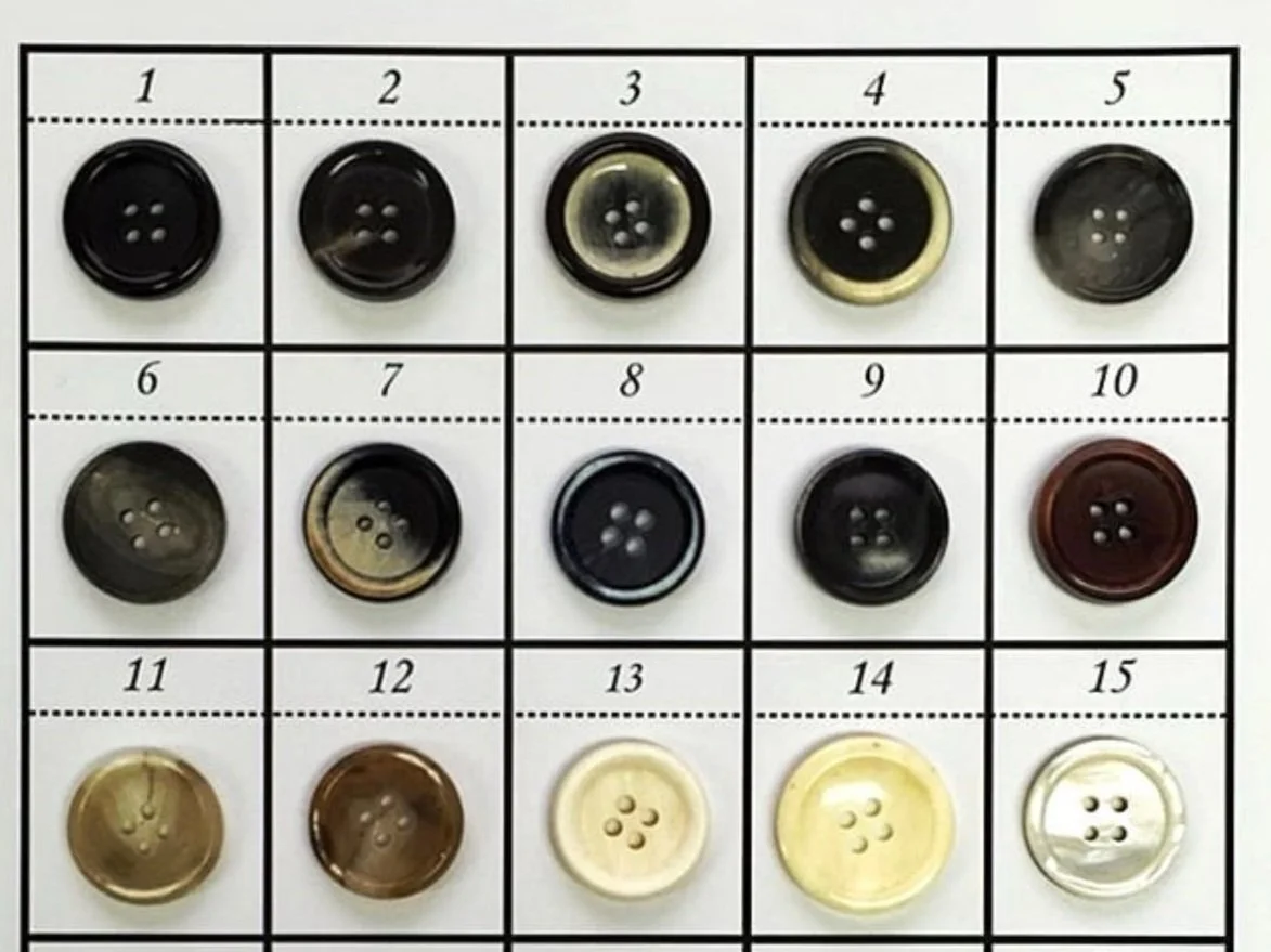 A grid of 15 different colored buttons arranged in 3 rows and 5 columns, each button with four holes.