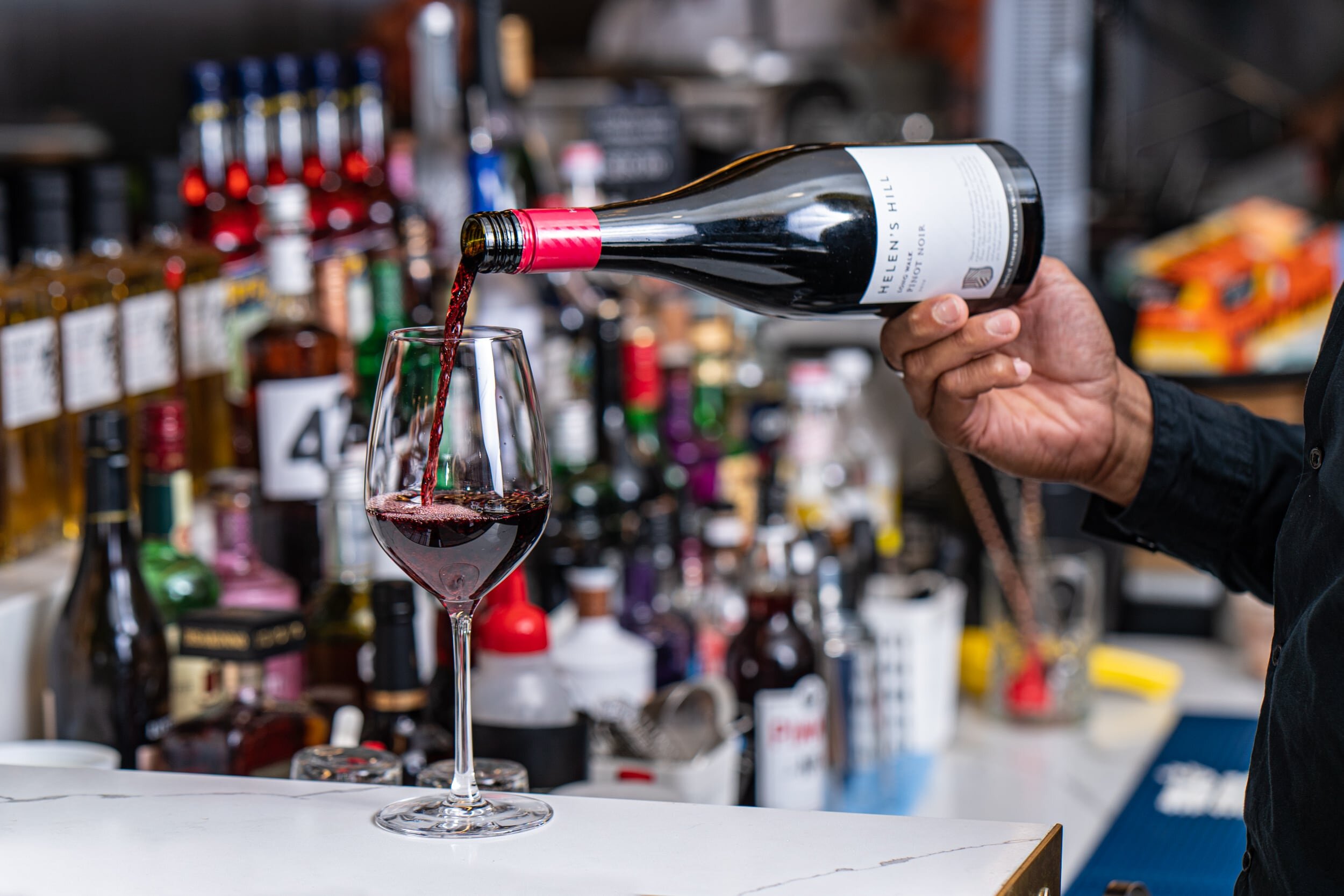 Bartender pouring red wine