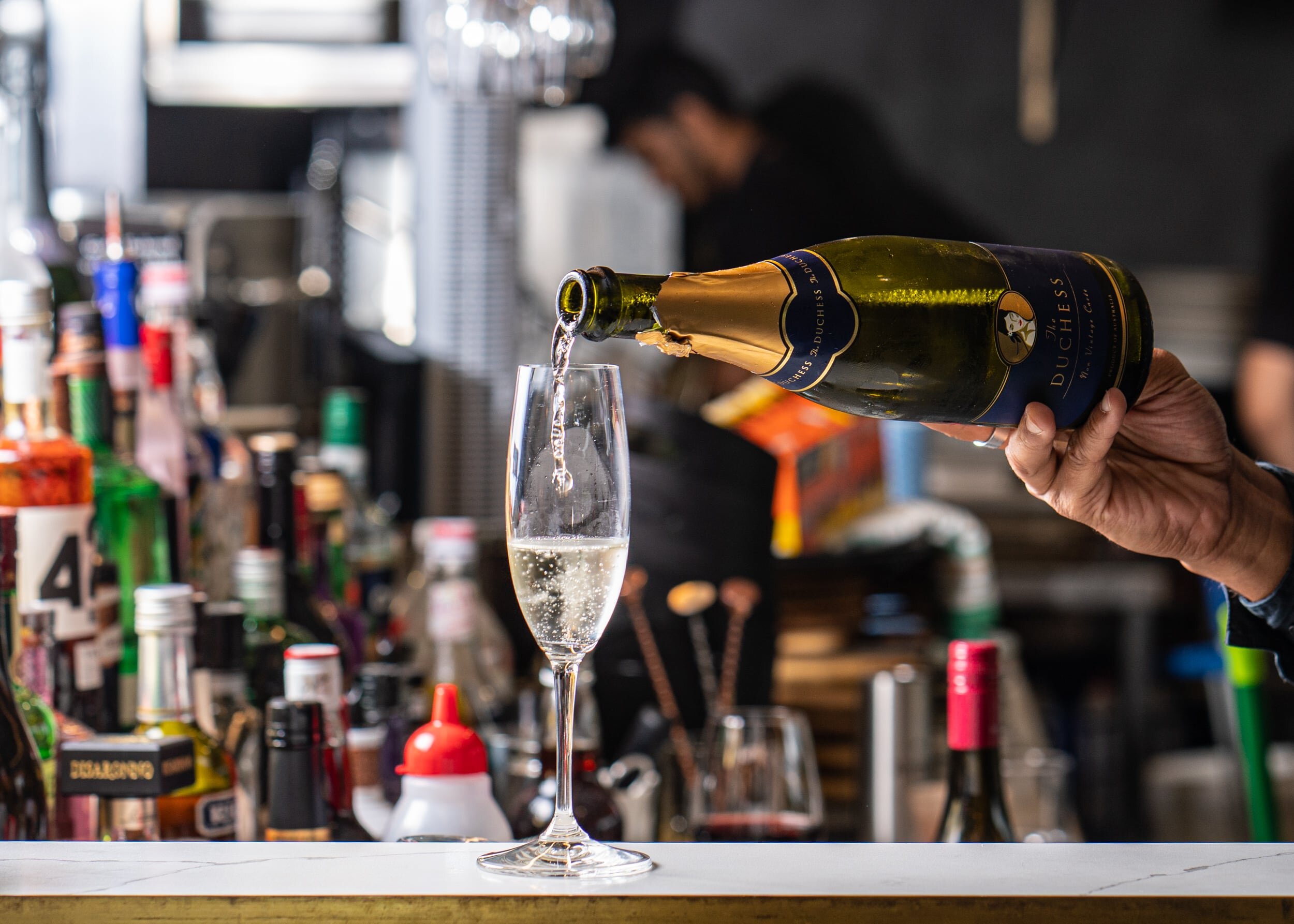 Champagne served poured by bartender at Garcon, French restaurant