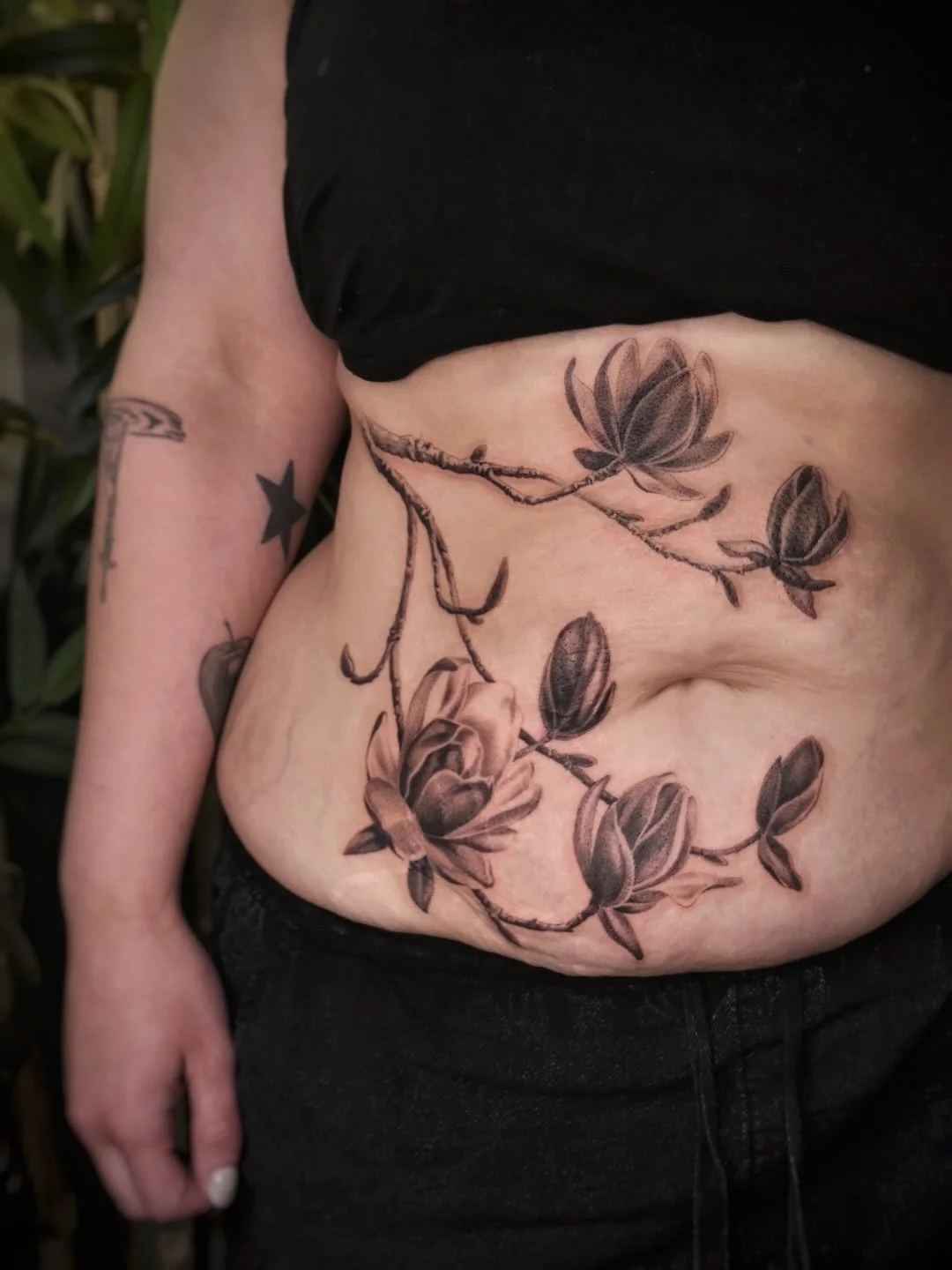 Magnolias from my predrawn for Baylis!! I love this piece SO much 💕🌸 Done in one session while guesting in Hendersonville, NC. 

#floraltattoo #planttattoo #botanicaltattoo #illustrativerealism #blackamdgreytattoo #magnolia #tummytattoo