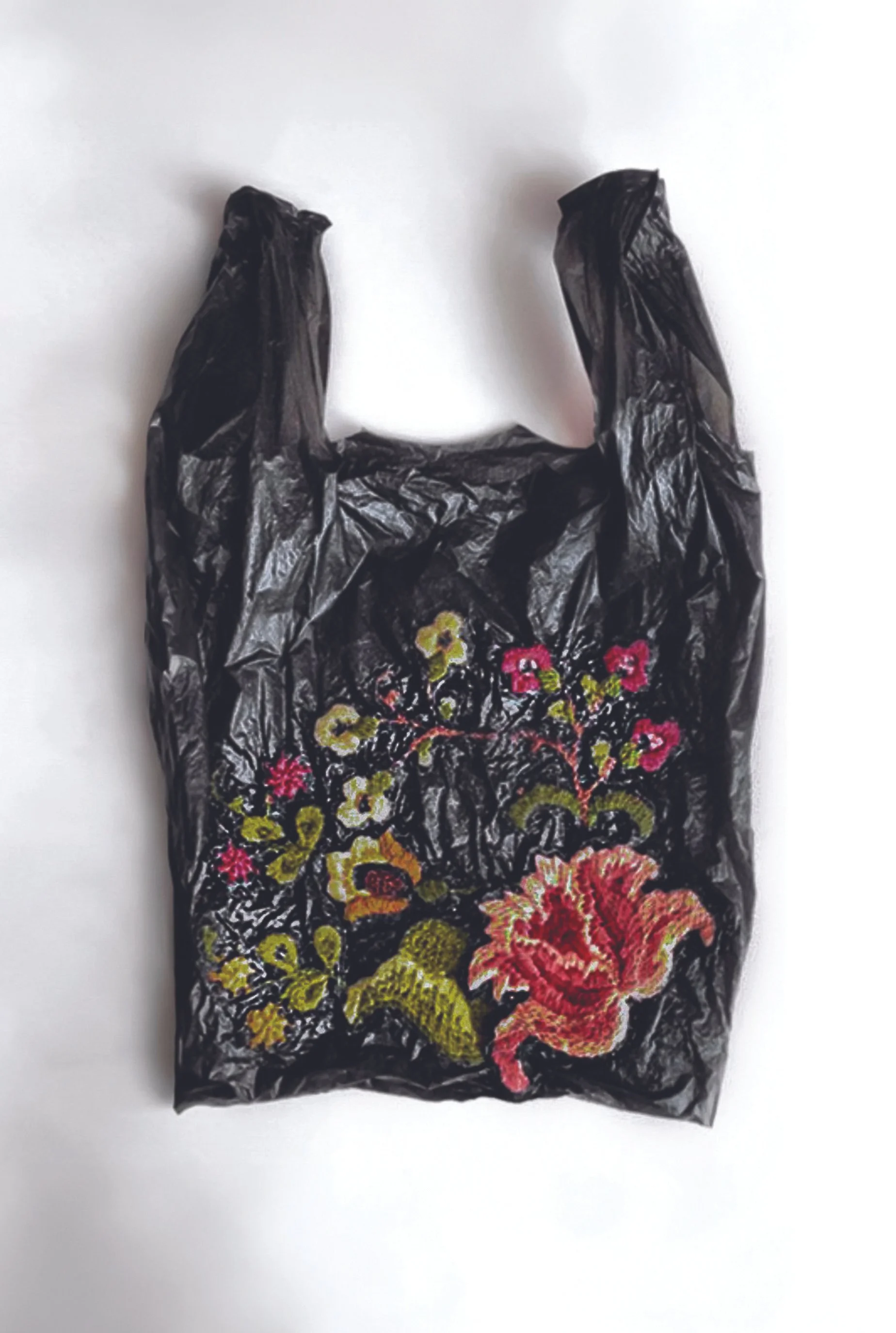 A black plastic shopping bag with embroidered floral design, including pink, yellow, and orange flowers and green leaves.