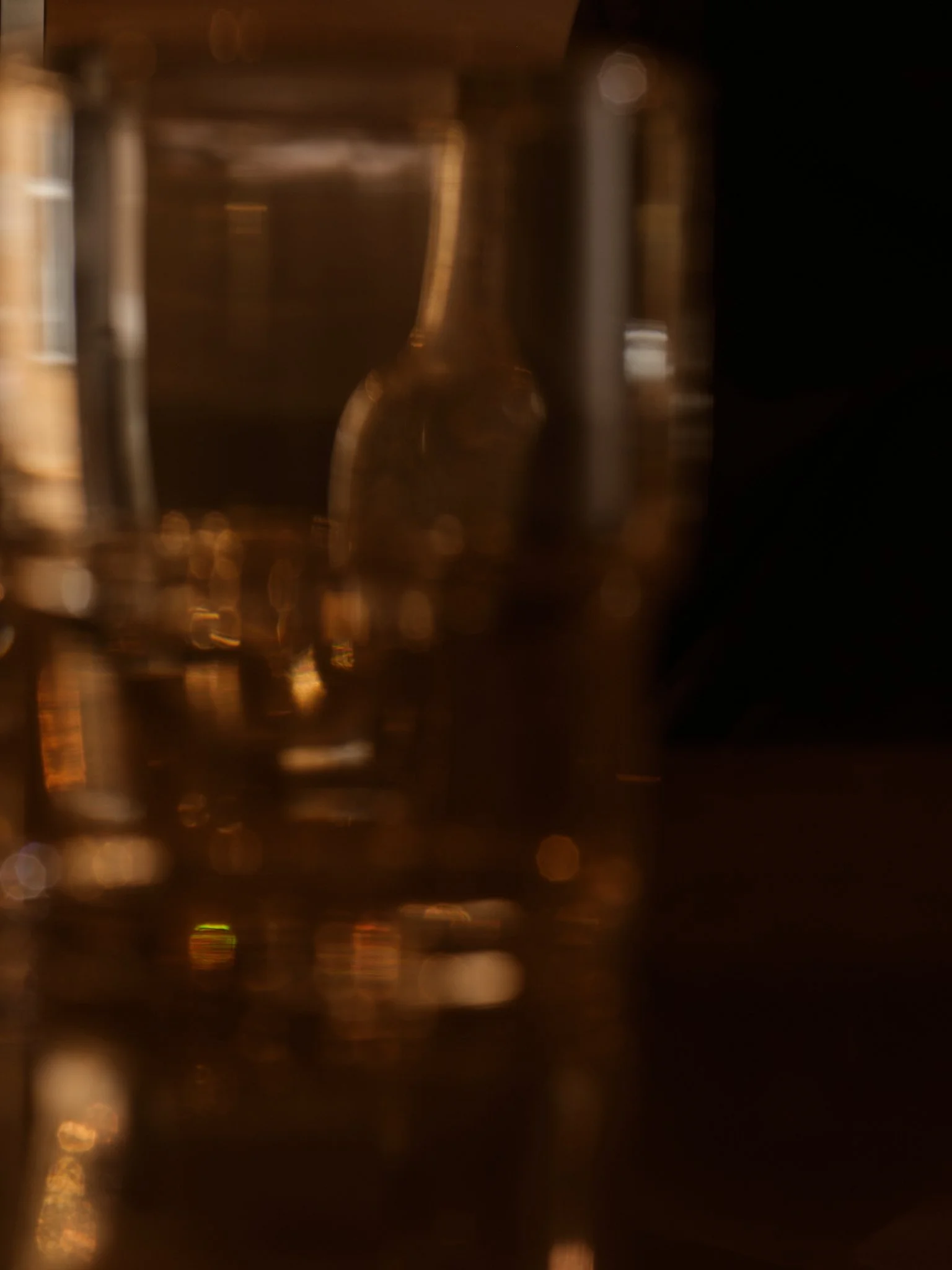 A blurry, dark image with some light reflections and shapes, but no clear or identifiable objects.