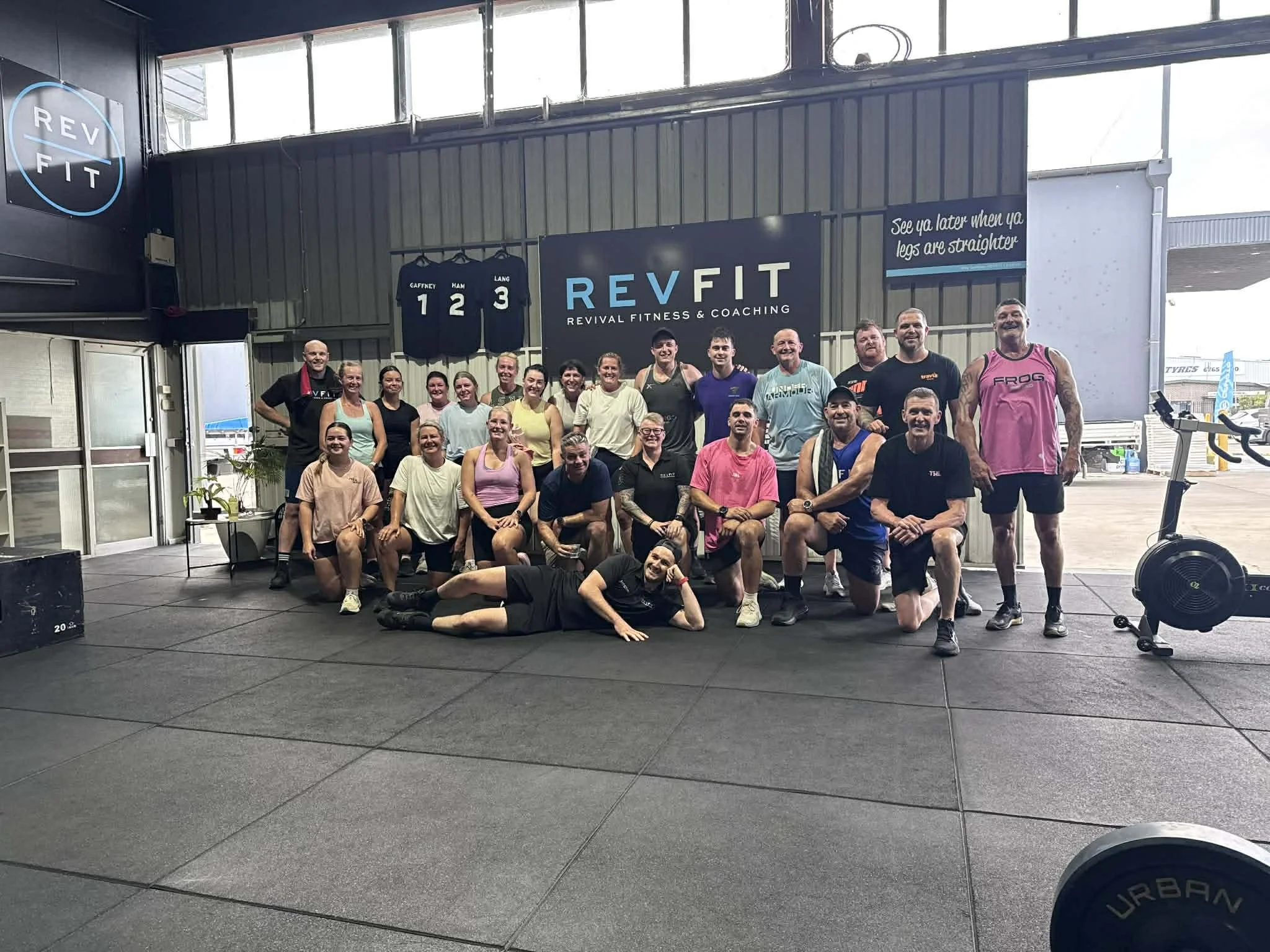 Group fitness class and personal trainer posing together after a workout session at RevFit gym in Taminda