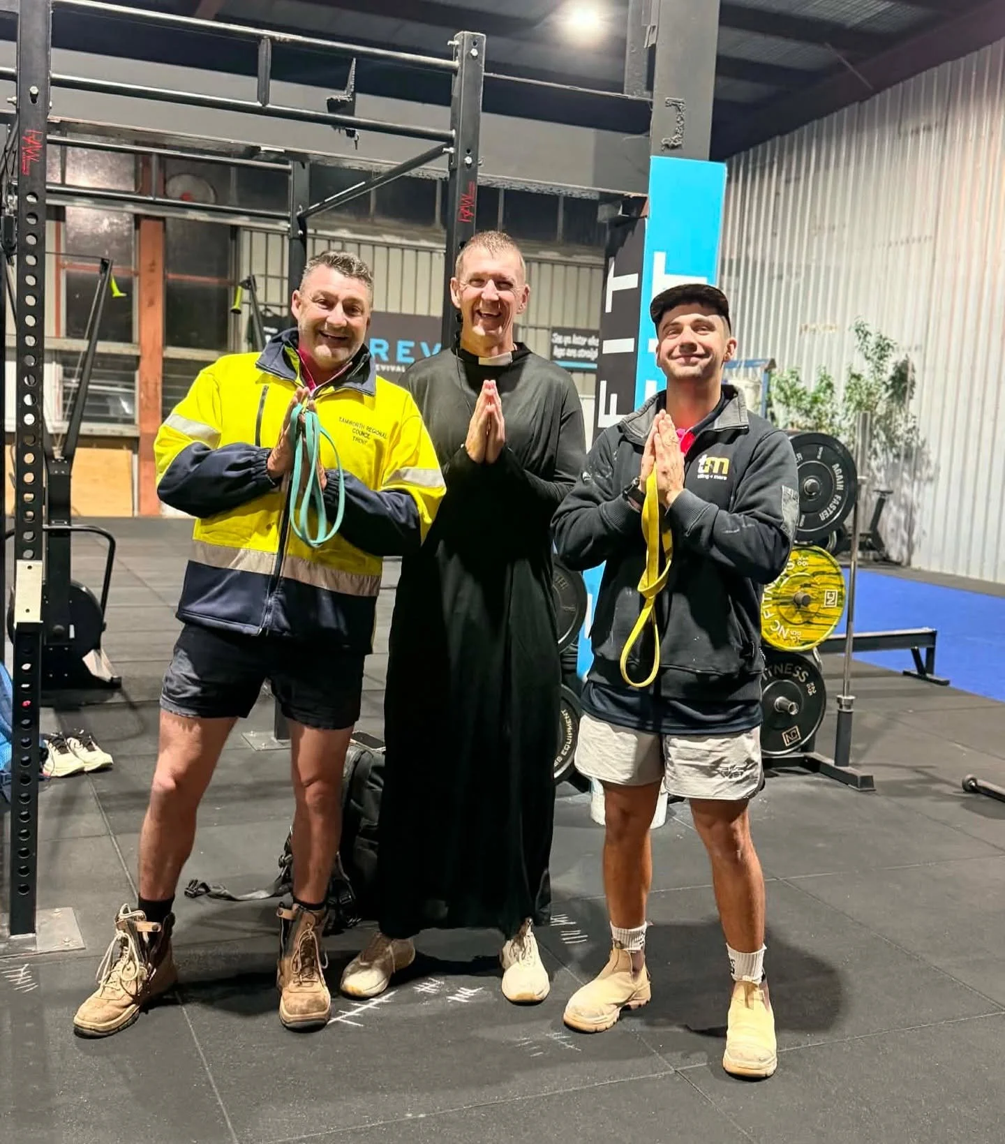 Members smiling and having fun during an energetic strength training session with resistance bands at RevFit gym in Taminda