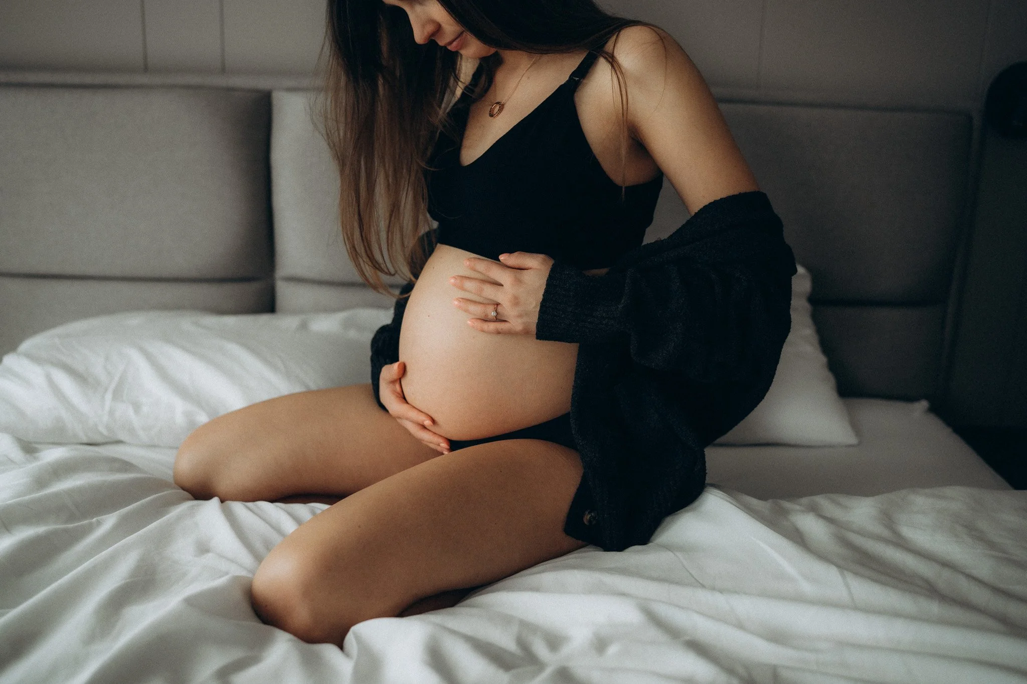 Detail těhotenského bříška v čistém interiéru