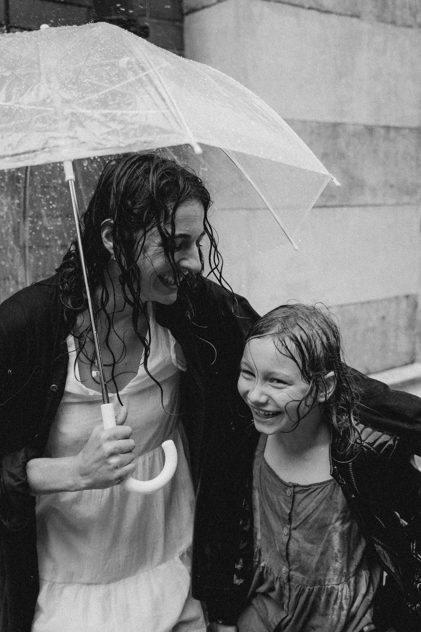 Maminka chrání dceru před deštěm při rodinném focení