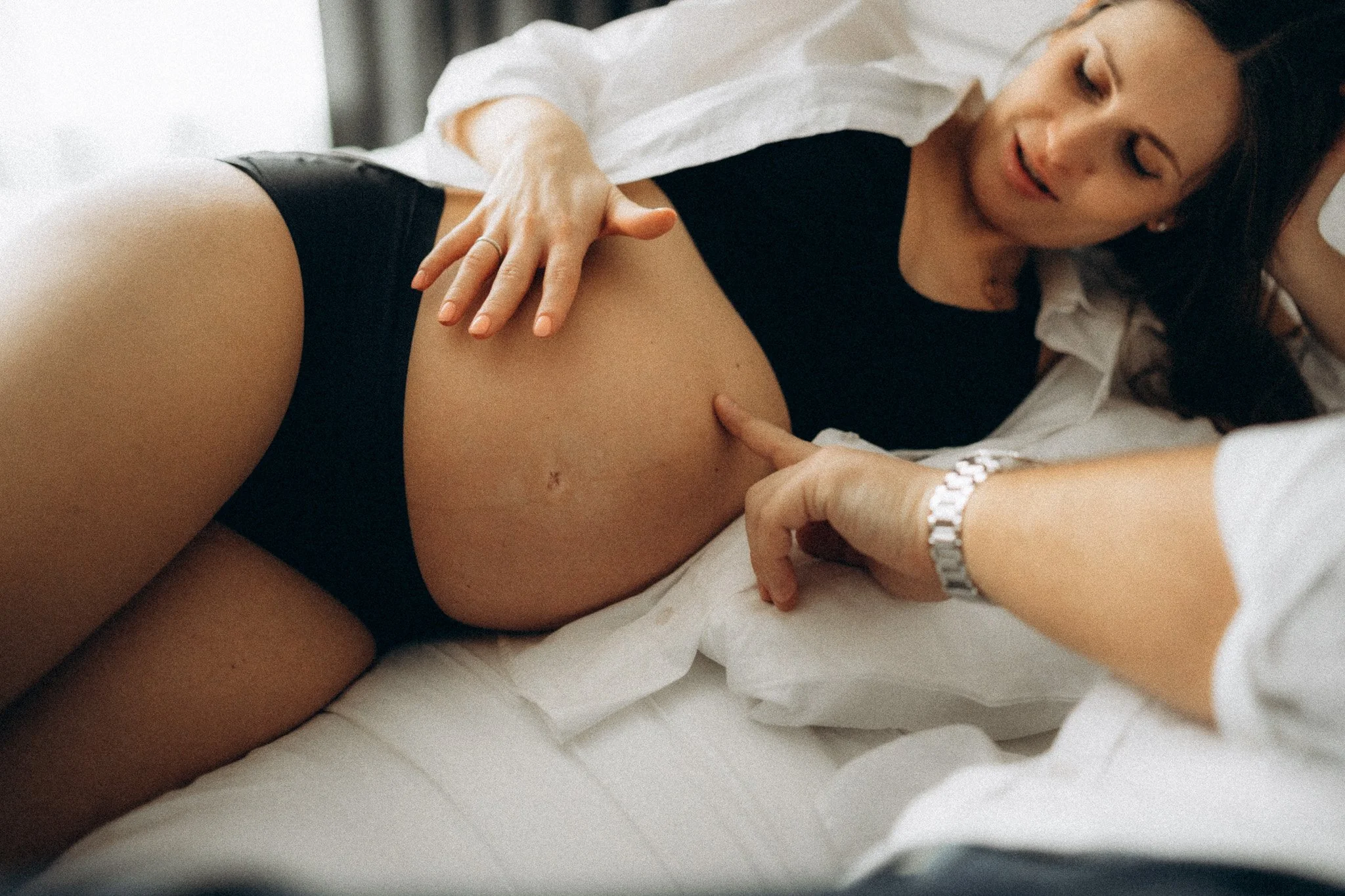 Intimní moment při těhotenském focení v moderním bytě