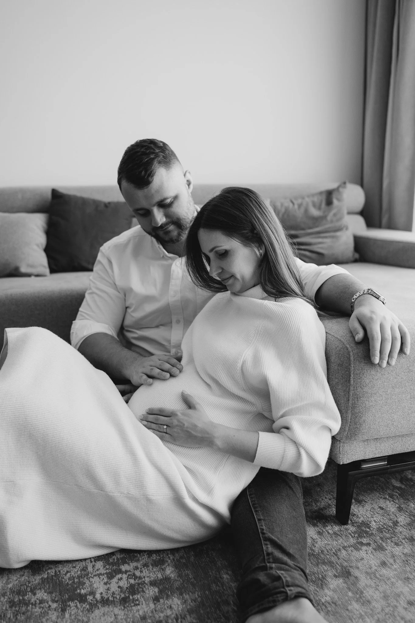 Pár sedící u gauče při těhotenském focení