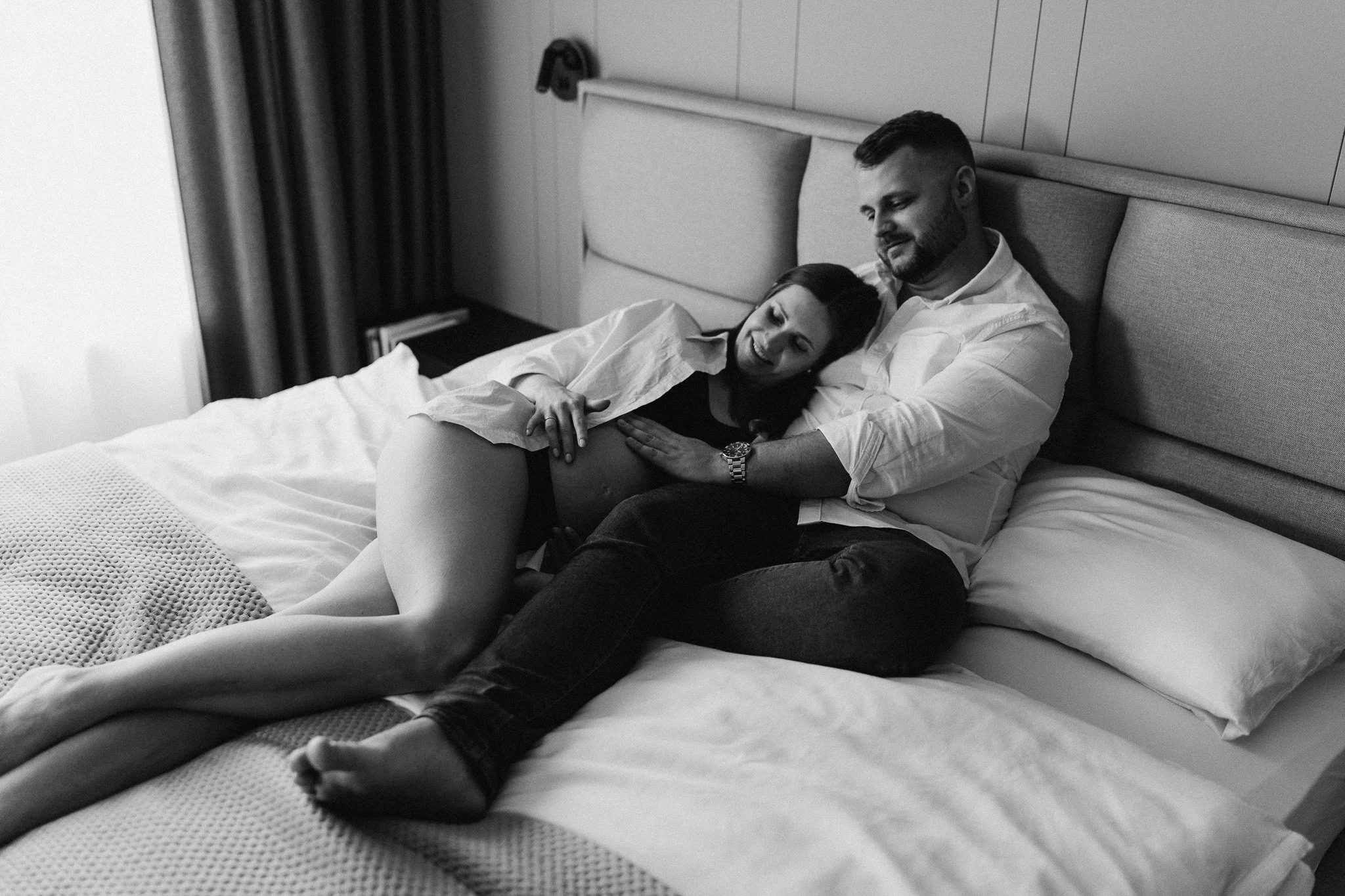 Těhotná žena opřená o partnera v domácím prostředí