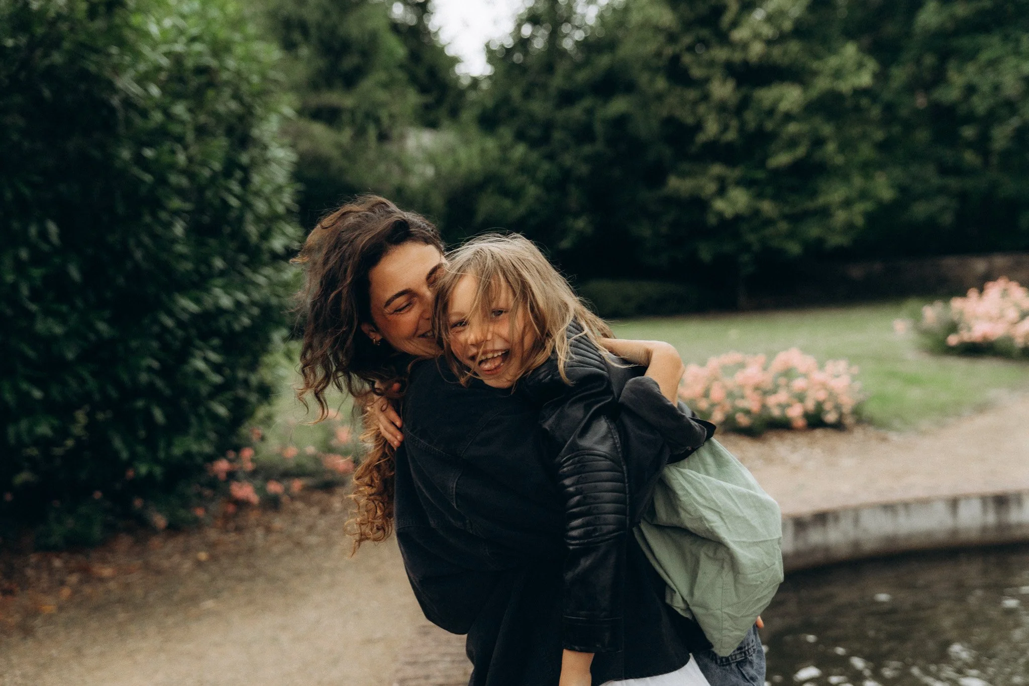 Maminka objímající dceru v deštivém prostředí