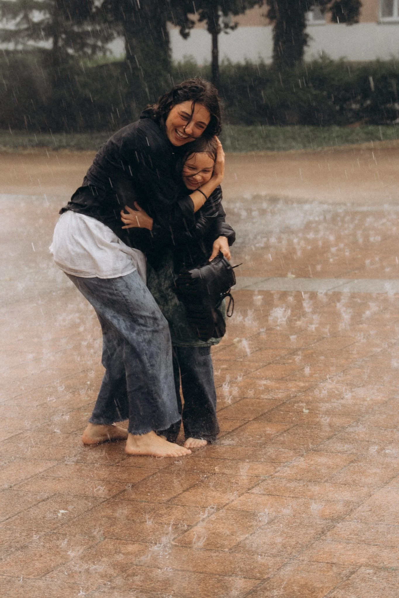 Detail objetí maminky a dcery během rodinného focení v dešti