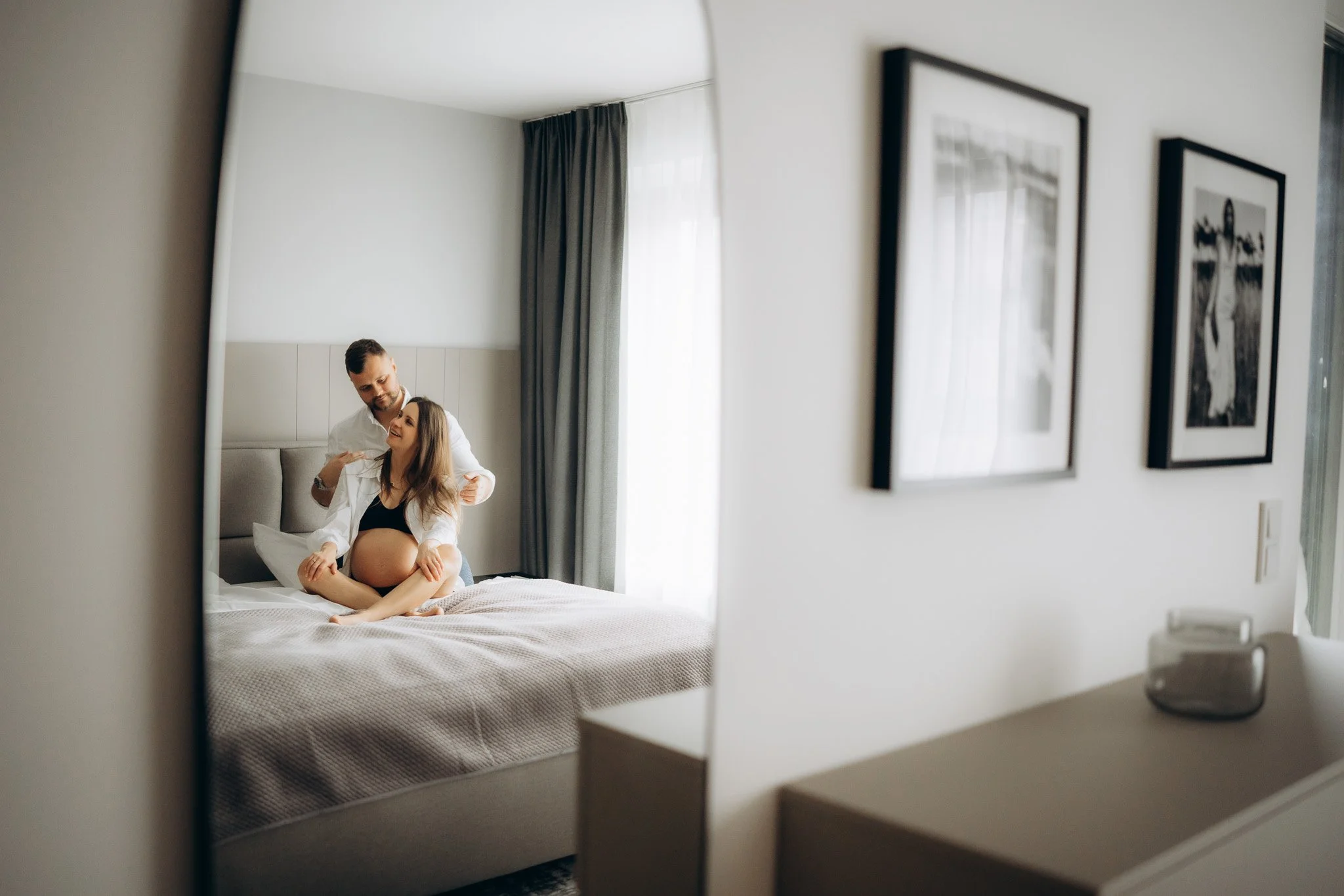 Těhotenský portrét páru na posteli v domácím prostředí