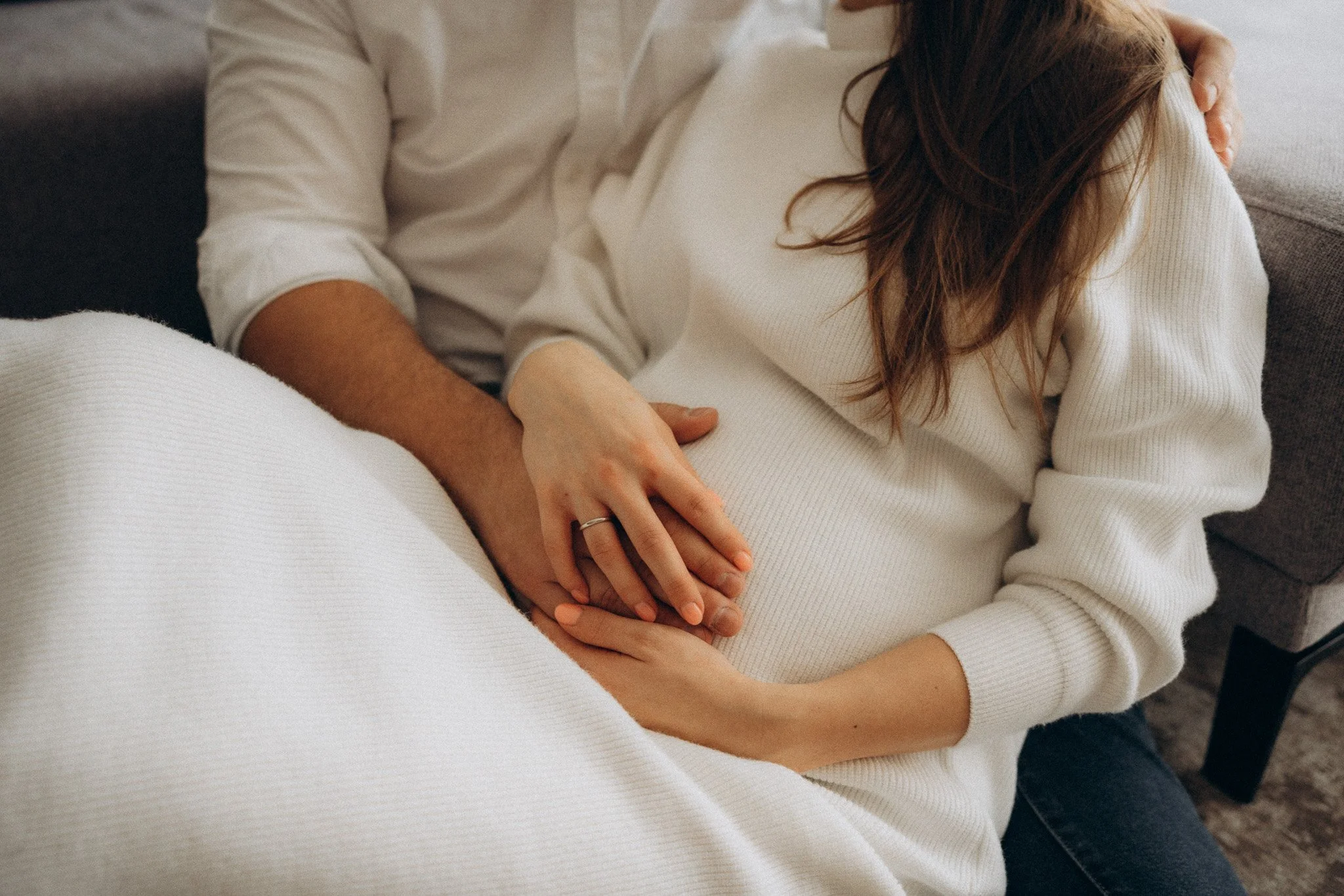 Detail rukou na těhotenském bříšku při focení doma