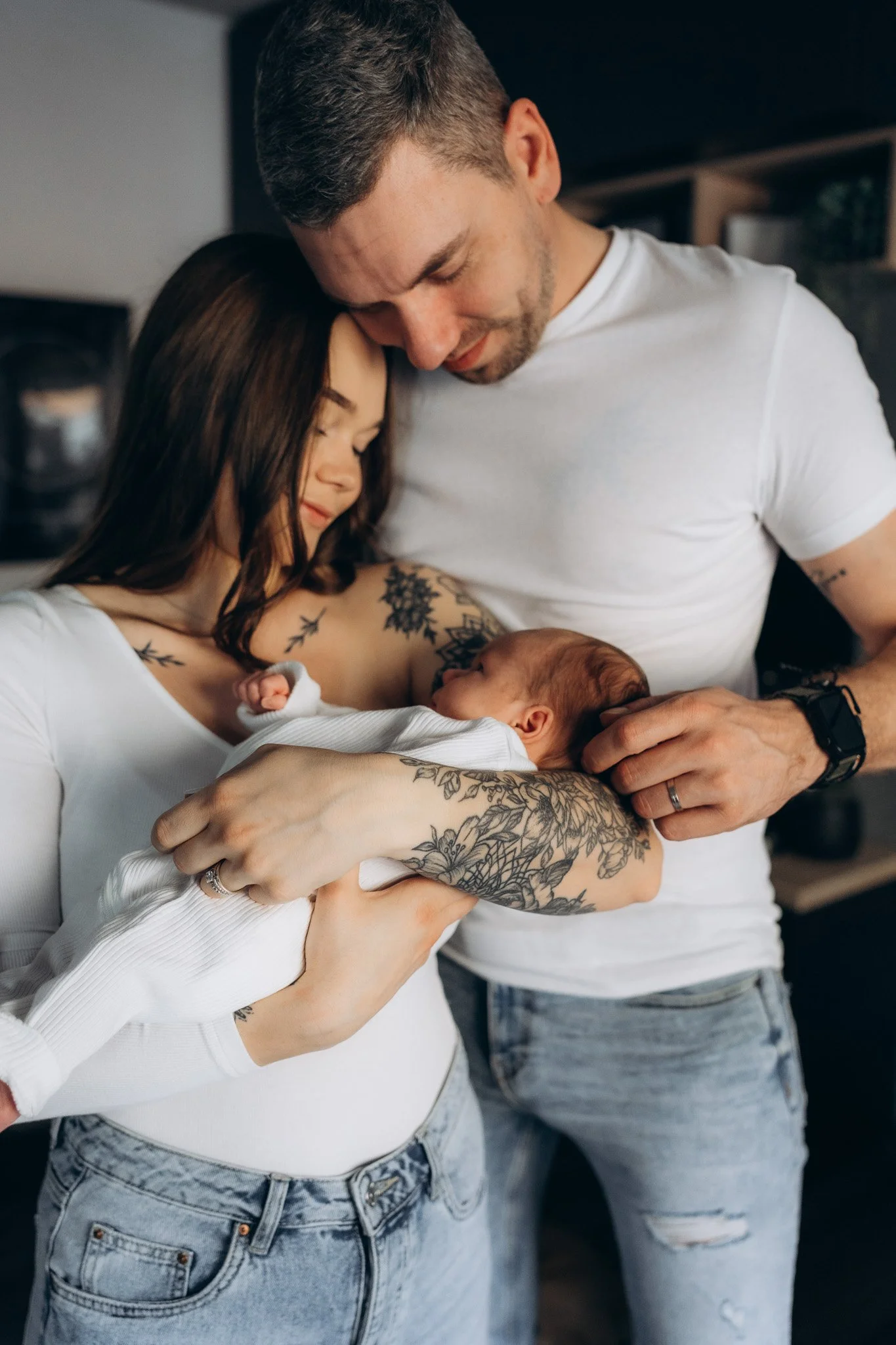 Rodinné novorozenecké focení doma – maminka a tatínek drží své novorozené miminko v náručí, intimní chvíle v obývacím pokoji
