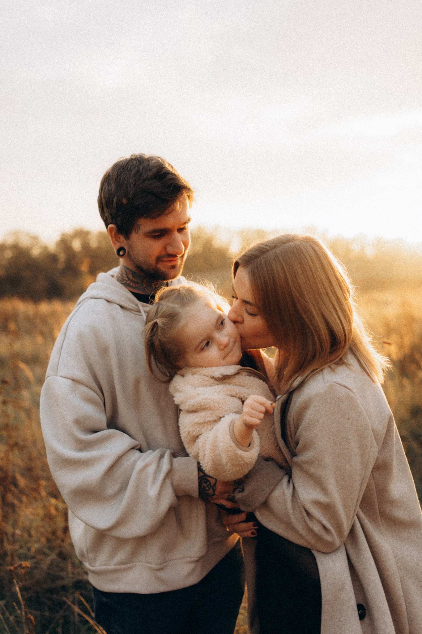 Rodinné focení maminky, tatínka a dcery při západu slunce v přírodě
