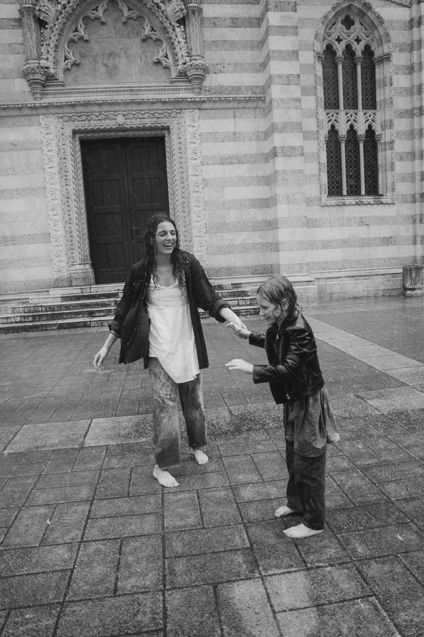 Maminka a dcera spolu během radostného deštivého okamžiku