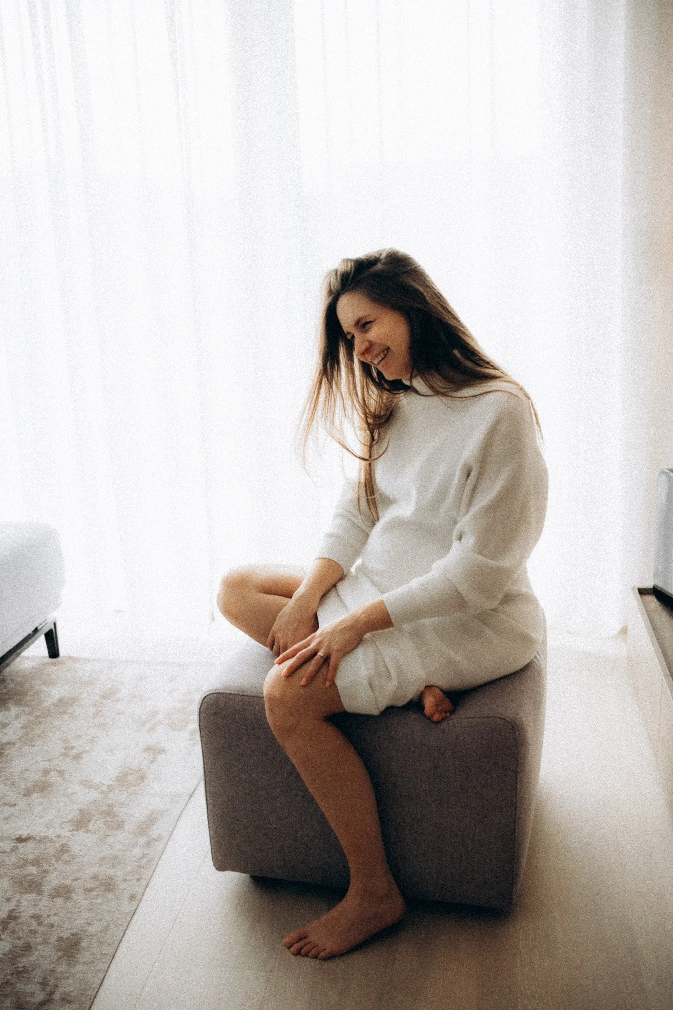 Těhotná žena sedící na gauči při focení doma