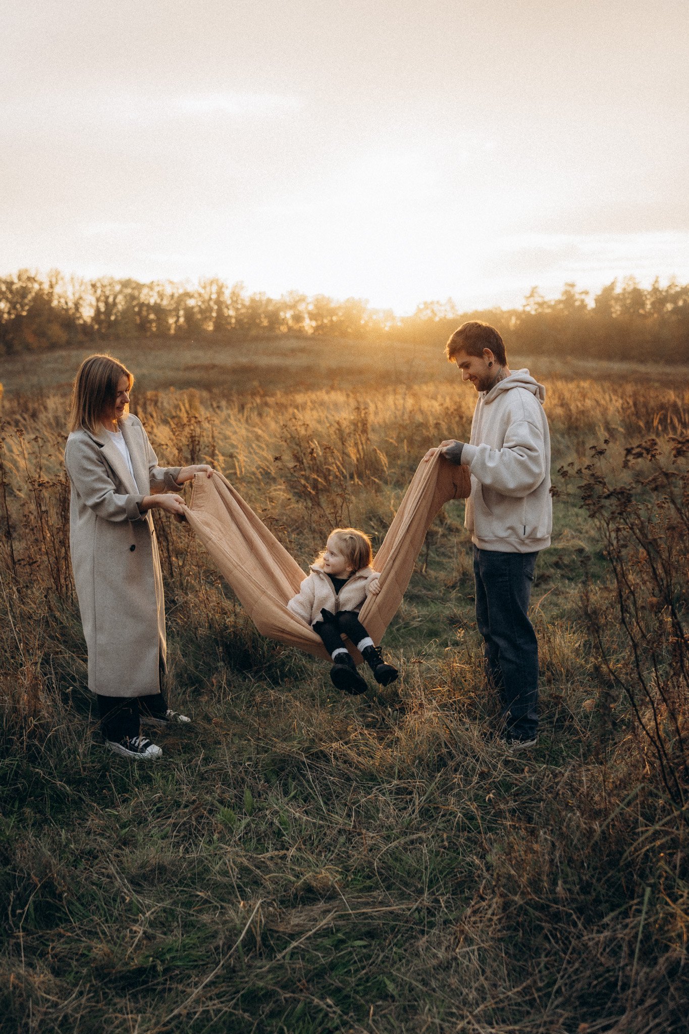 Maminka, tatínek a dcera při focení v otevřené krajině