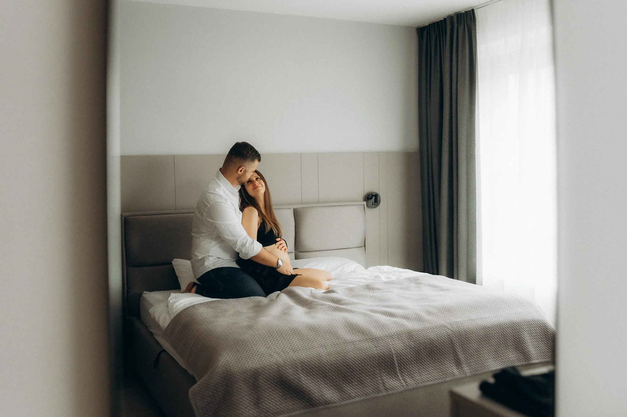 Pár při očekávání miminka v minimalistickém prostoru