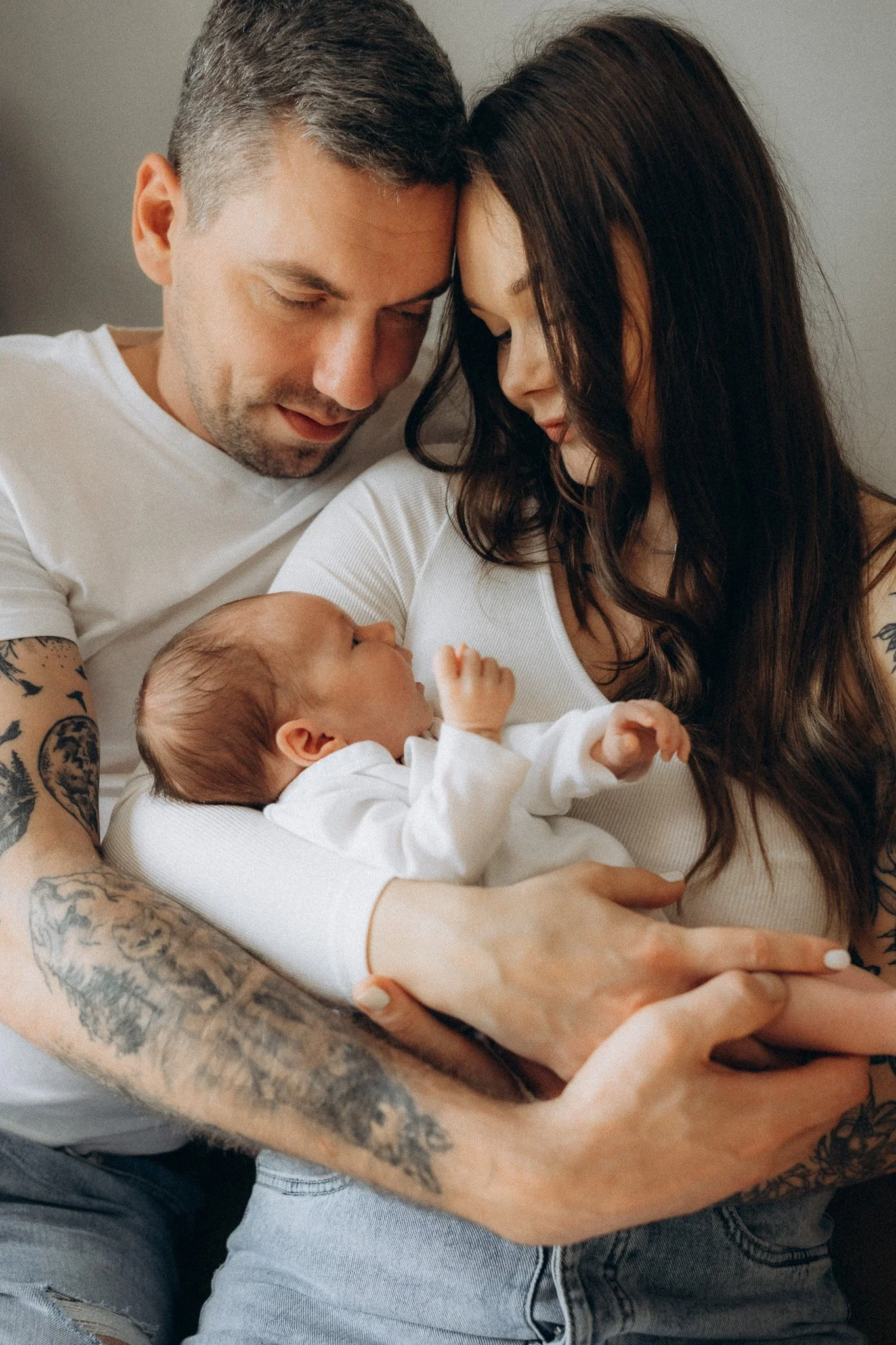 Maminka a tatínek objímají novorozence během klidného momentu