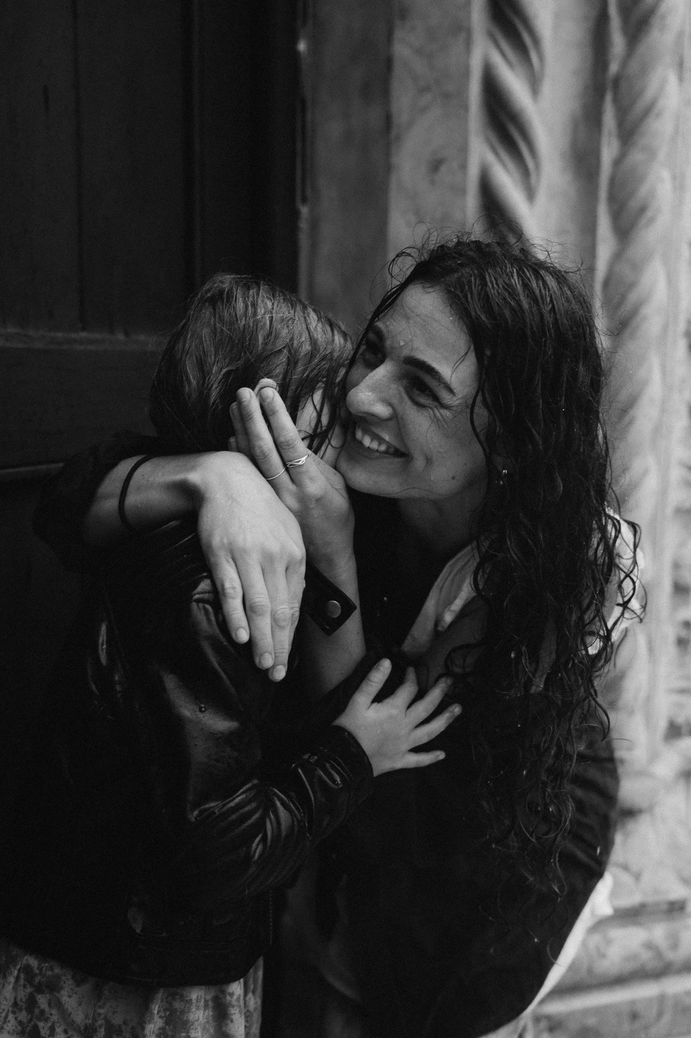 Maminka objímající dceru při focení v dešti