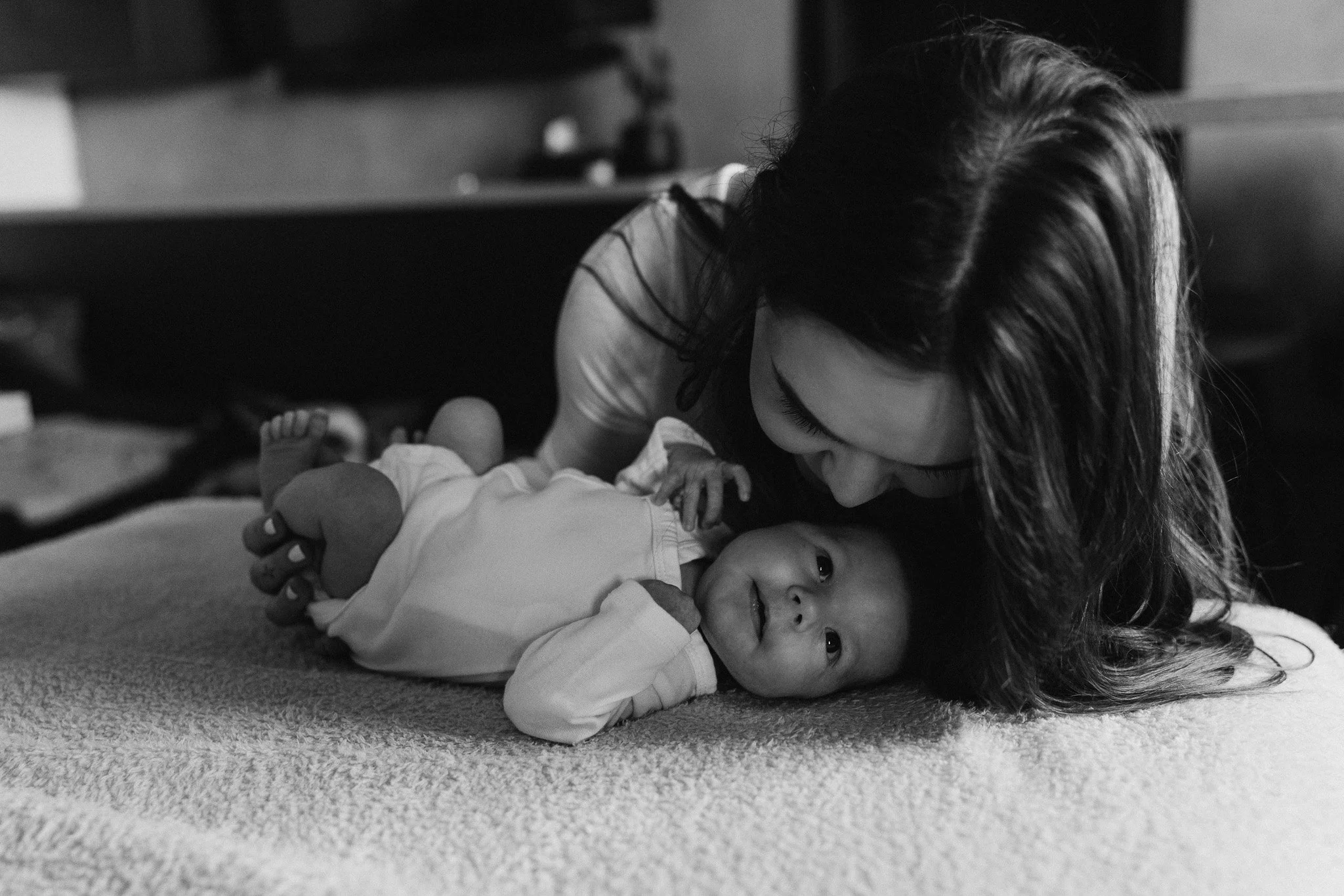 Maminka dává miminku pusinku při přirozeném světle