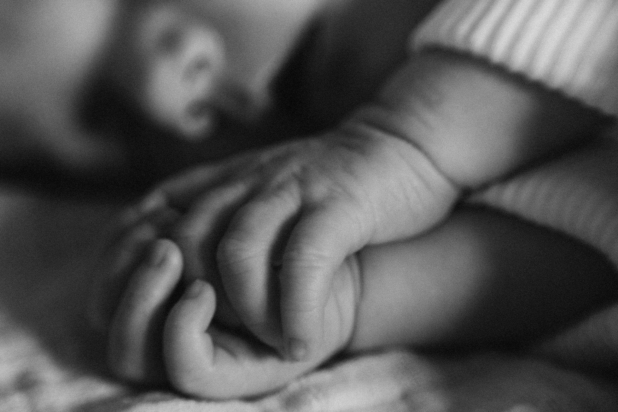 Jemný detail rukou novorozence během domácího focení