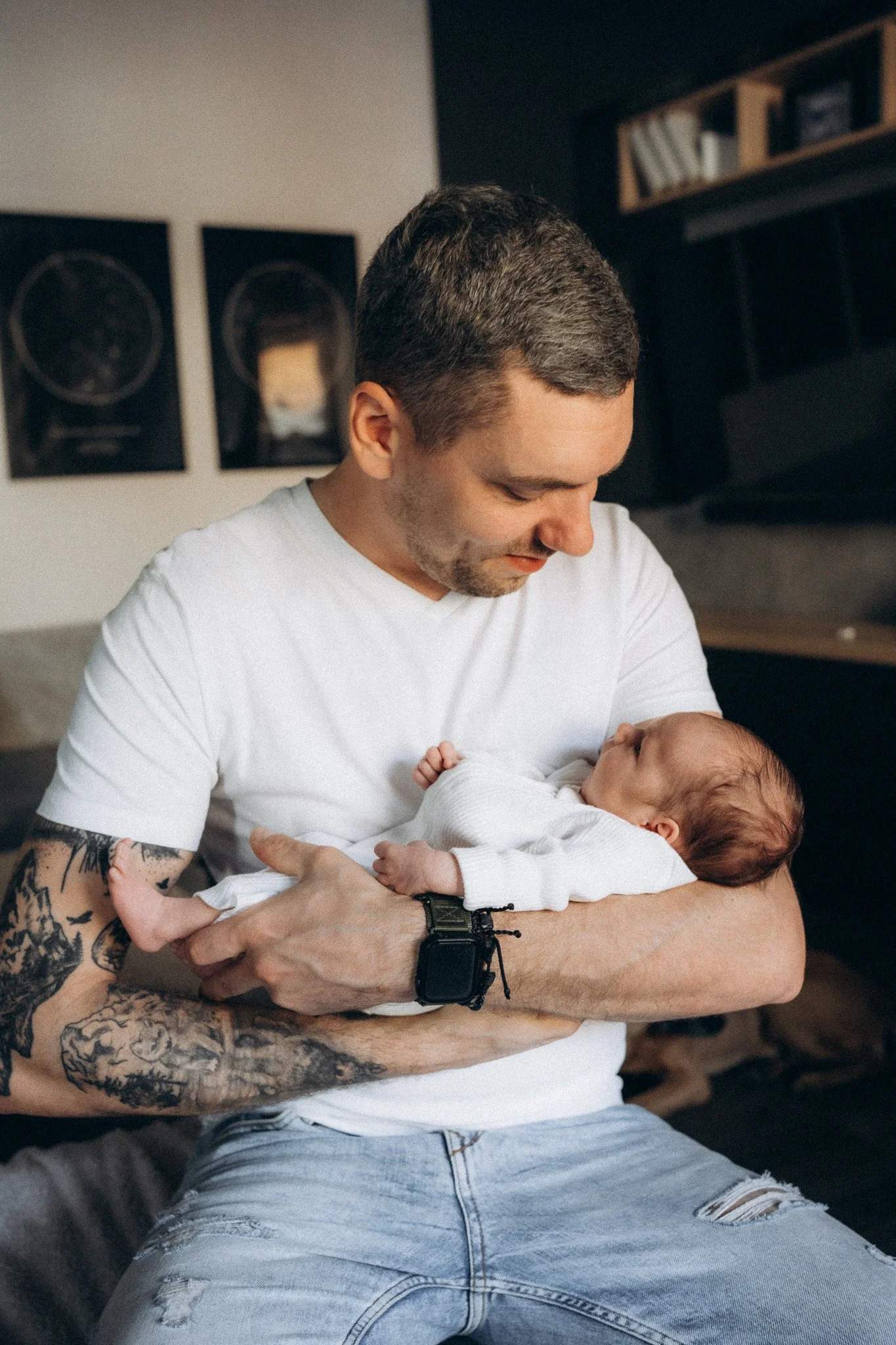 Tatínek držící novorozence v náručí při přirozeném focení