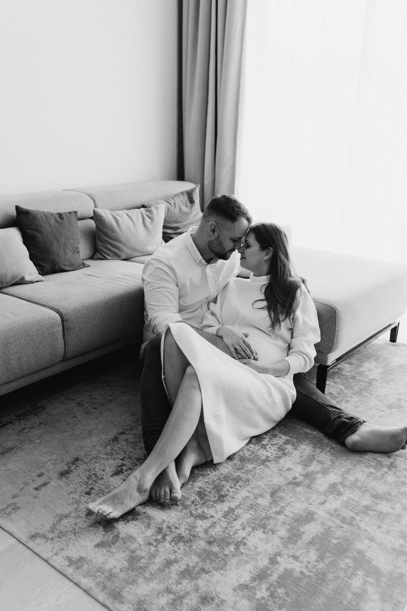 Těhotná žena s partnerem při focení u nich doma