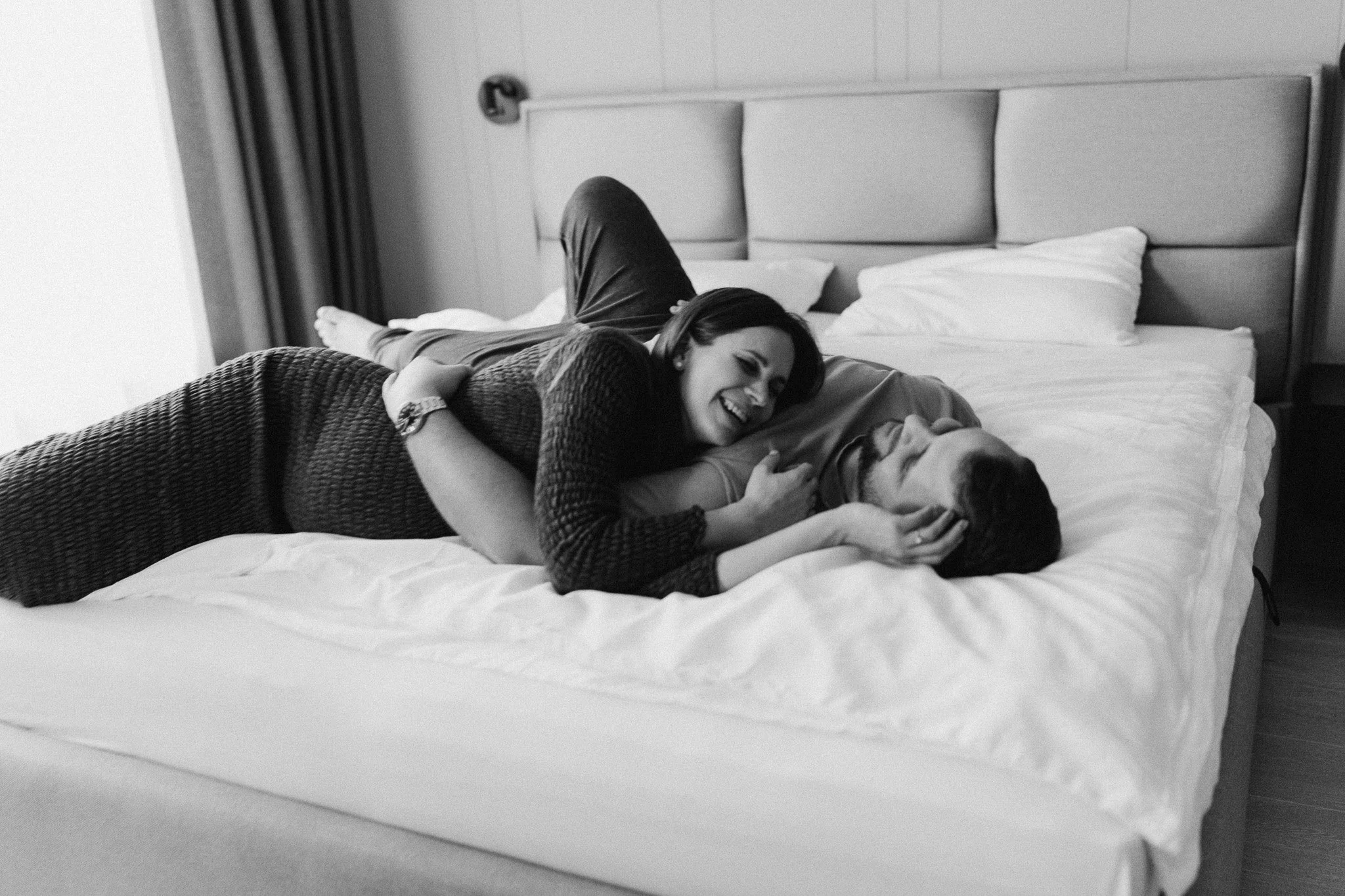 Těhotenský portrét páru na posteli v domácím prostředí