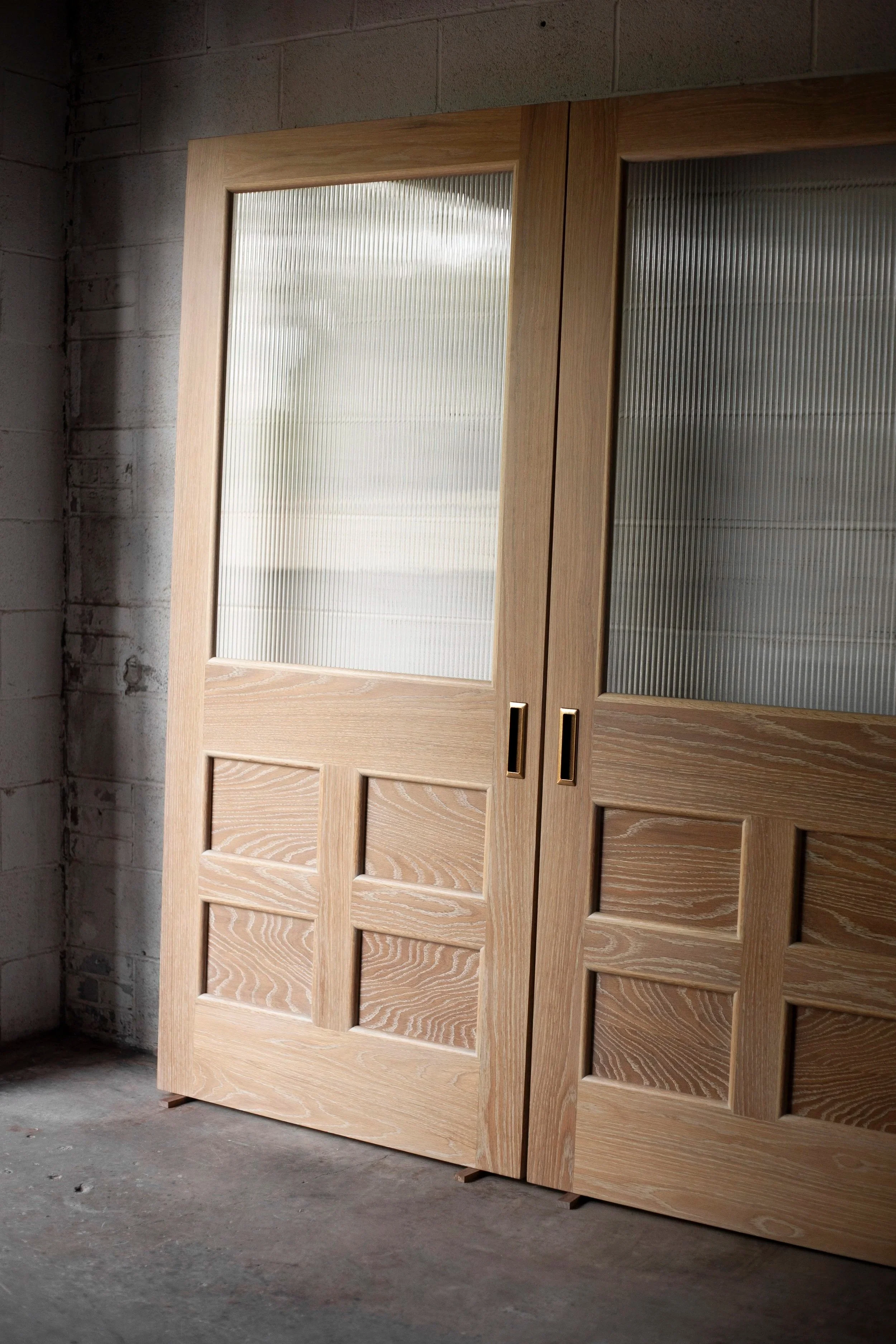 white oak sliding pantry doors with brass hardware