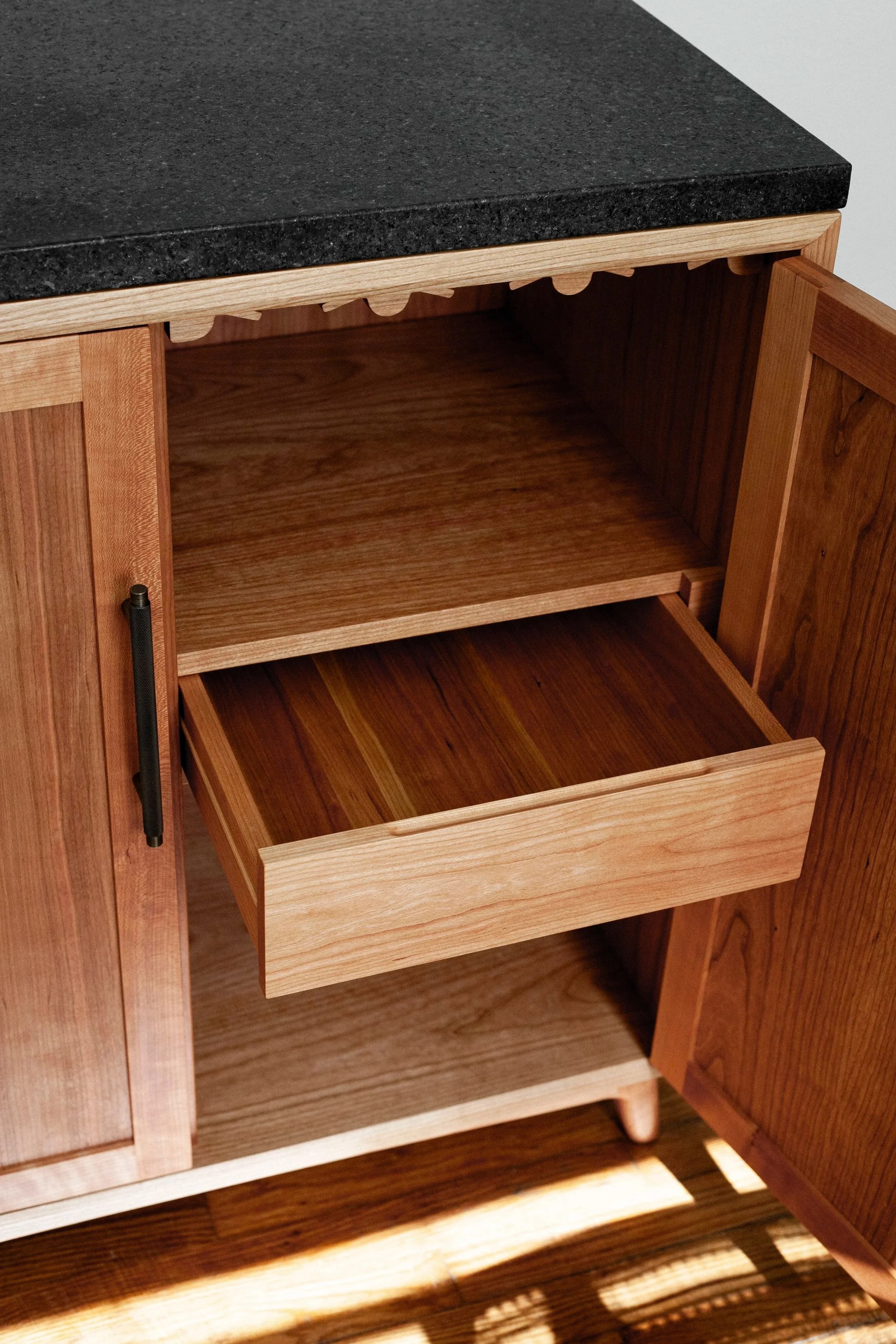 cherry bar cabinet with dark granite countertop, inset shaker doors, invisible hinges, and dark bronze hardware