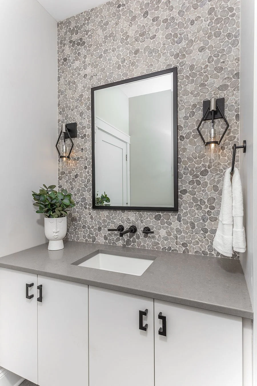 Bathroom vanity with gray quartz countertop undermount sink gray pebble wall tile black wall mounted faucet floating vanity Cleveland Ohio
