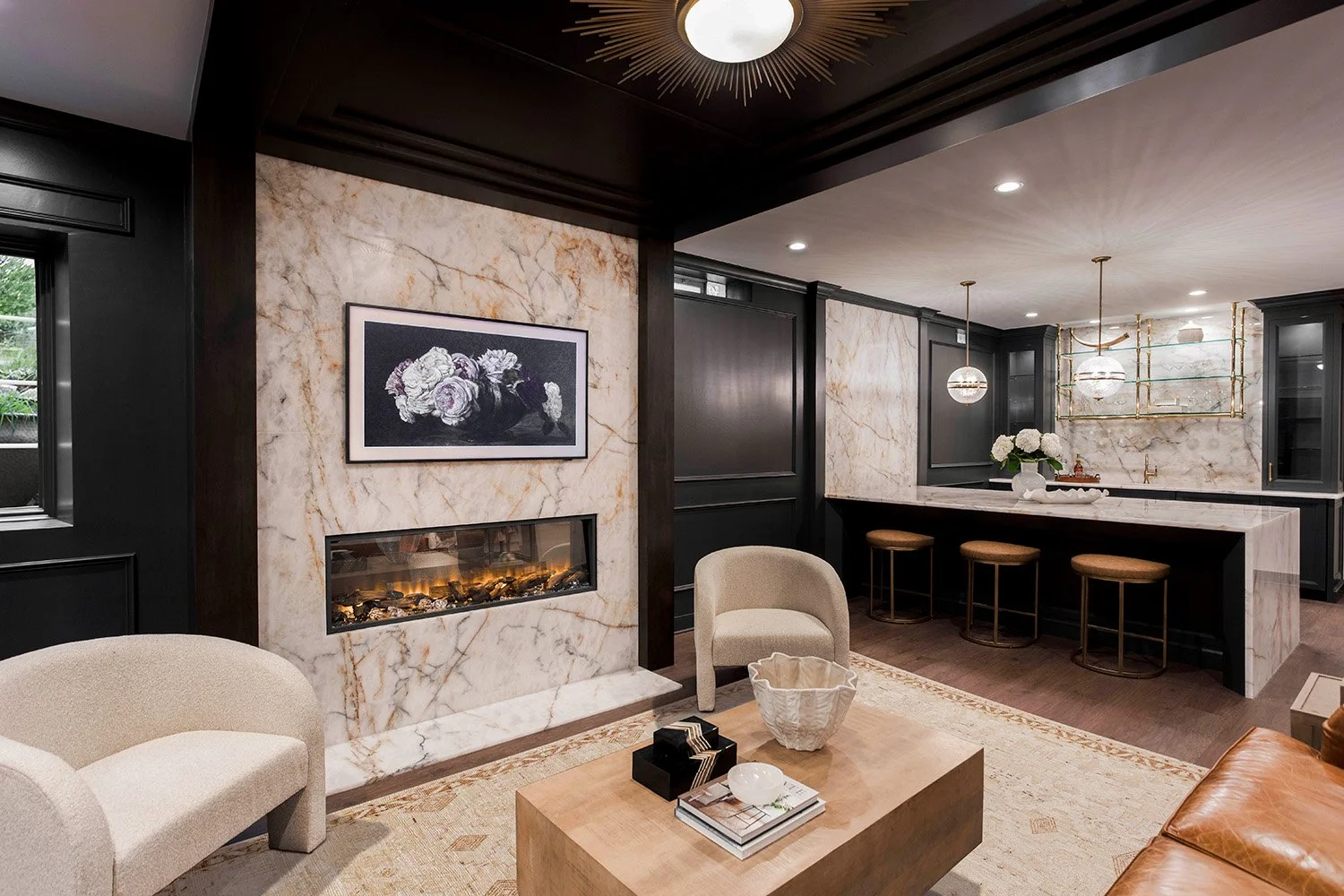 Dramatic lower level lounge with dark walls, Crystal Thunder quartzite bar, boucle seating, a linear fireplace, and moody ambient lighting | Ducy Design