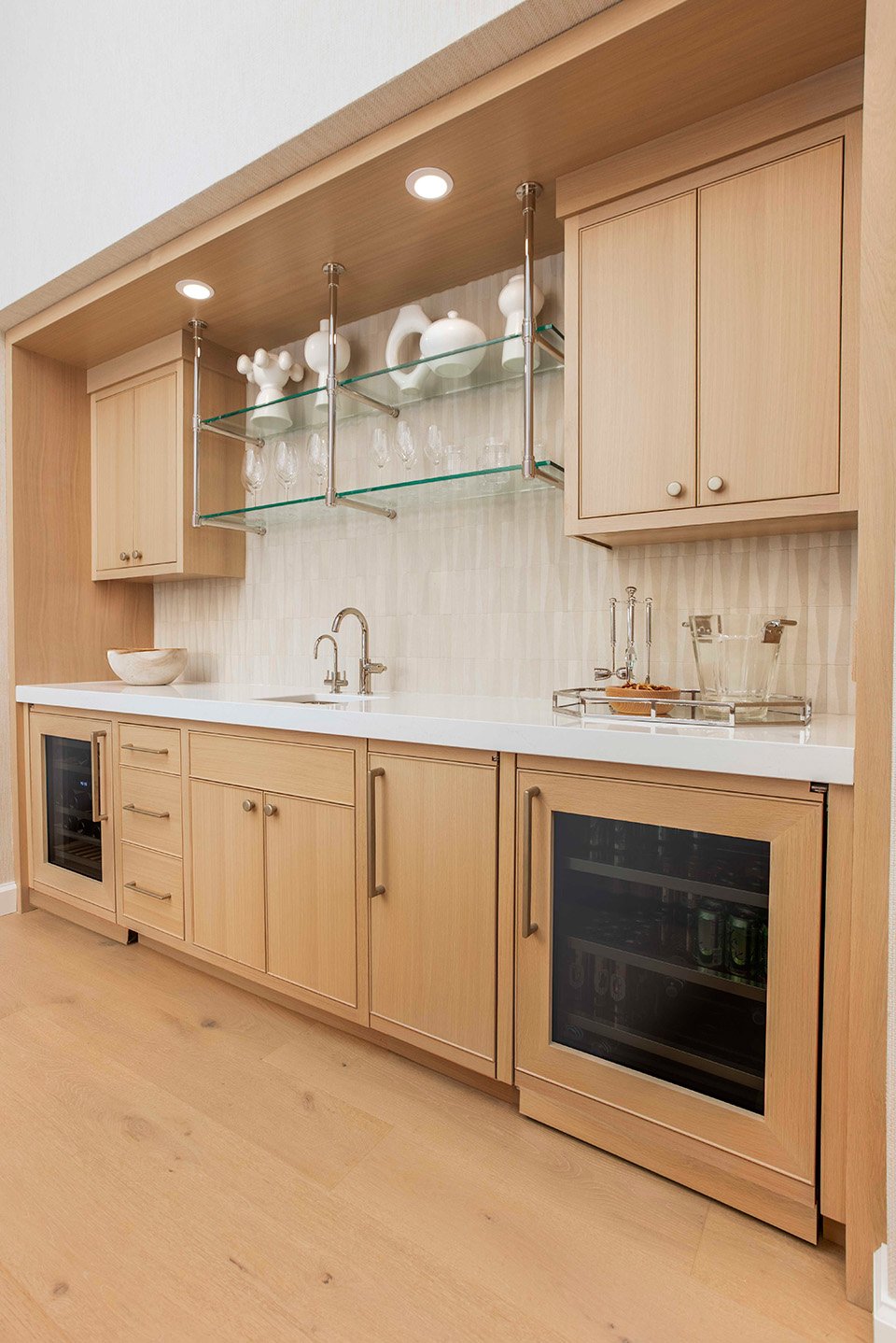 Kitchen detail with warm wood lower cabinetry, a built-in range wall, and a view into the dining and living areas of the lakehouse | Ducy Design