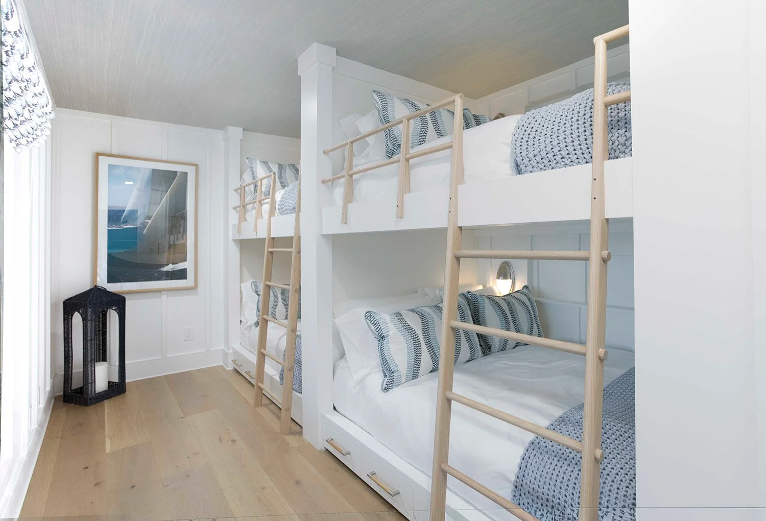 Custom bunk room with built-in white bunk beds, navy blue curtain accents, and bright natural light designed for a lakehouse family retreat | Ducy Design