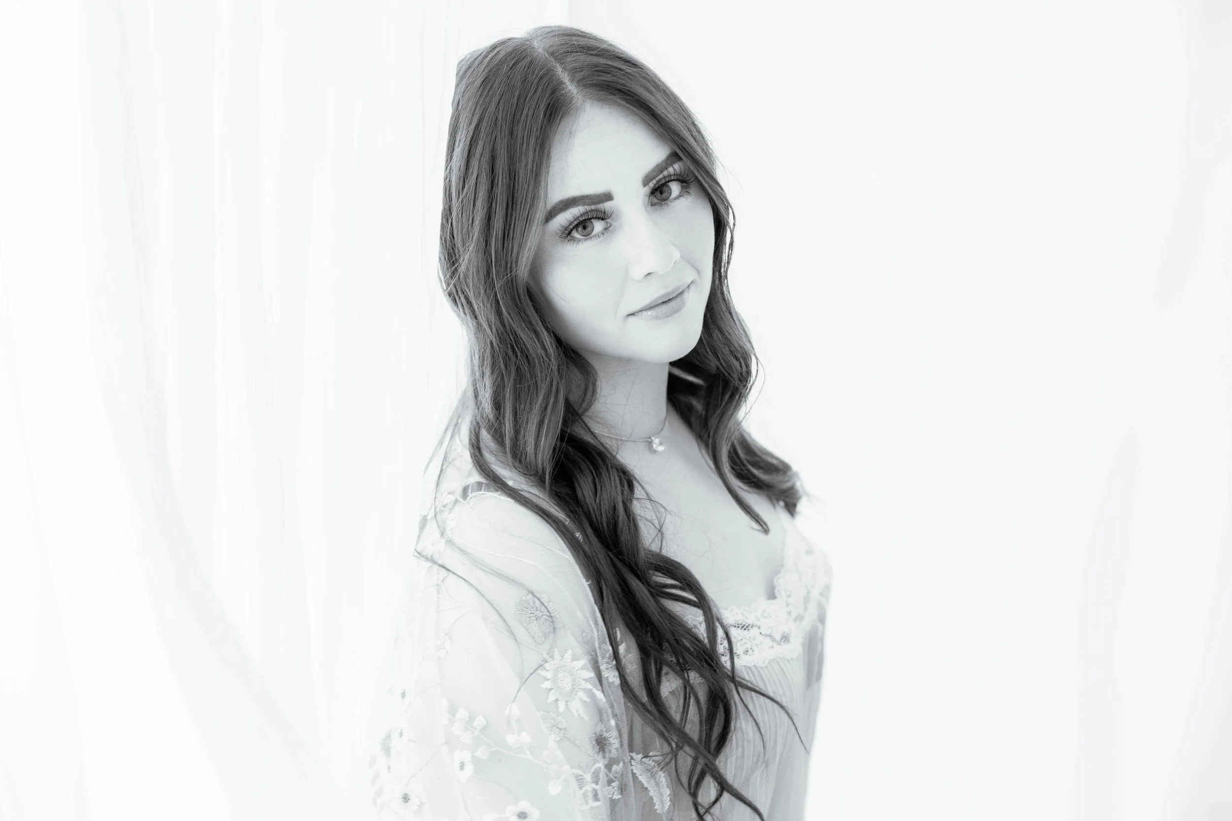 Playing in the sheer white curtains of my studio, this beautiful brunette with the doe eyes looks amazing draped in a sheet embroidery robe and a gown that allows her dark lingerie to make itself know.