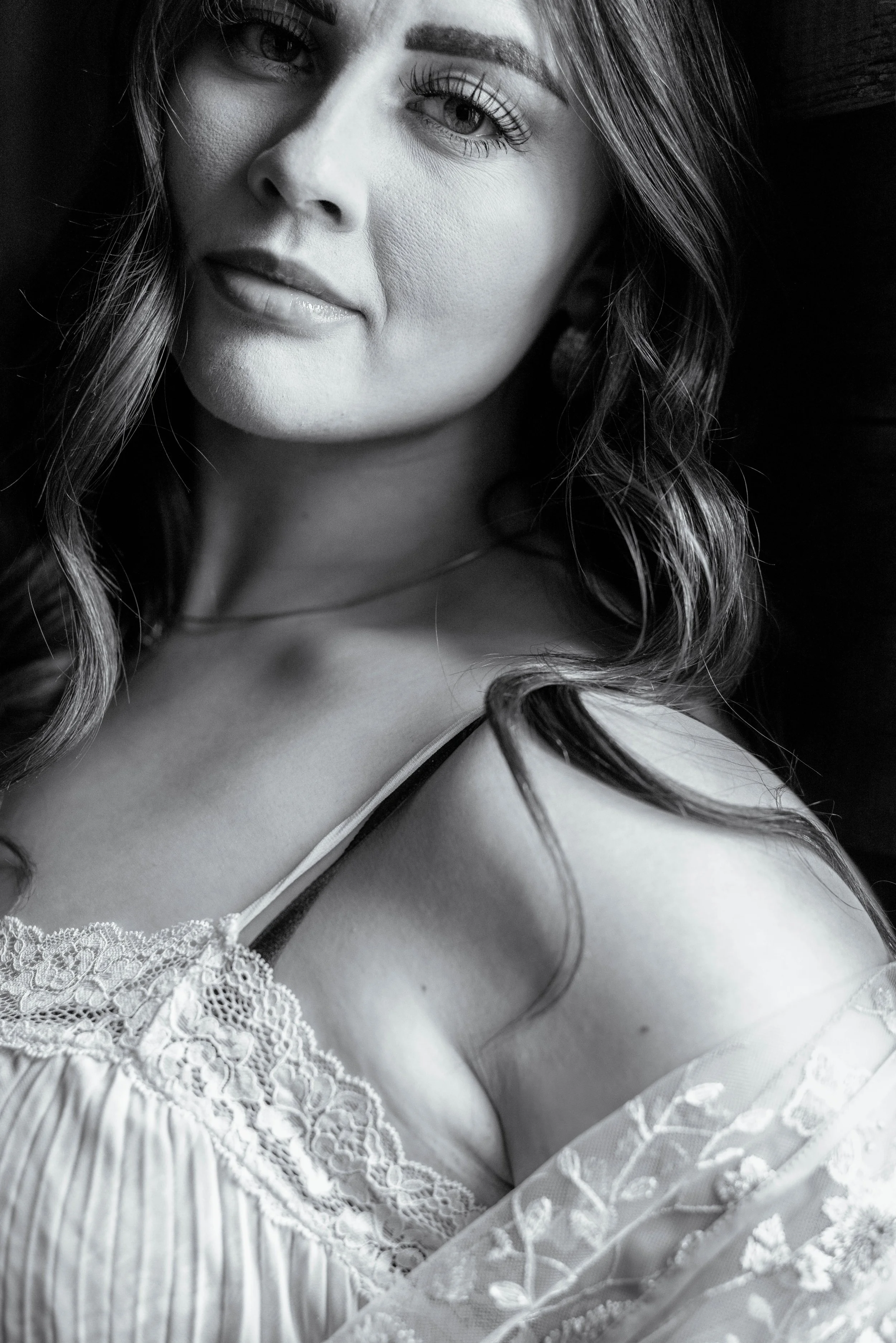 This closeup of a woman with beautiful eyes framed by stunning eyelashes demonstrates the beauty of a woman allowing herself to be unique in how she presents herself. Her white sheer pleated gown showing her dark lingerie underneath is stunning.