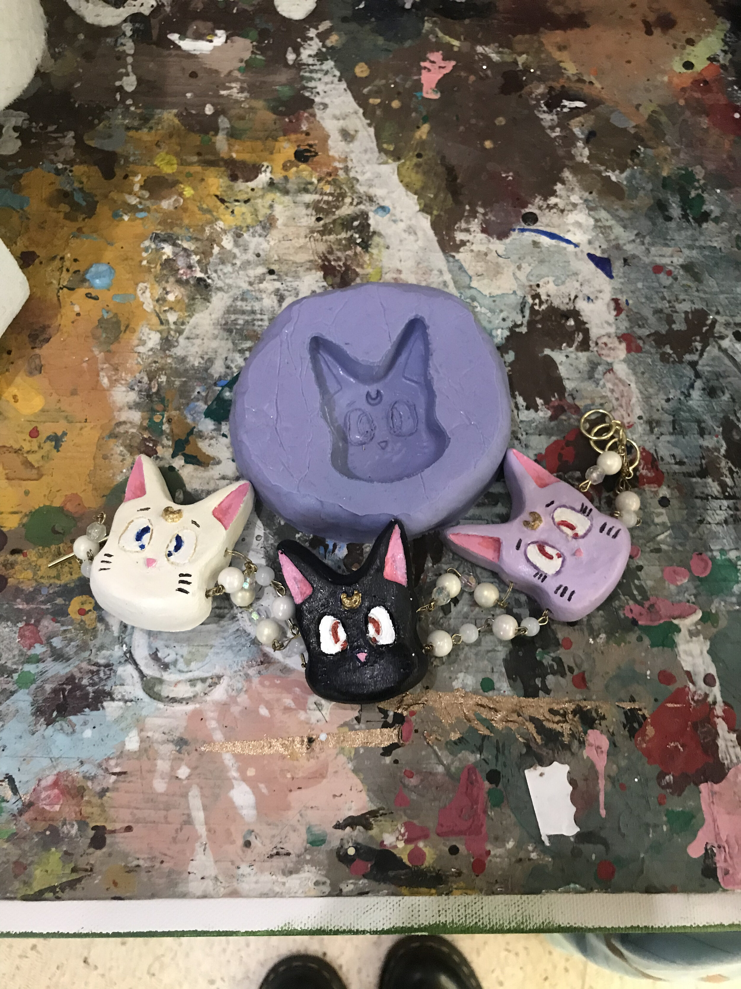 Cast resin pendents, painted and foiled.