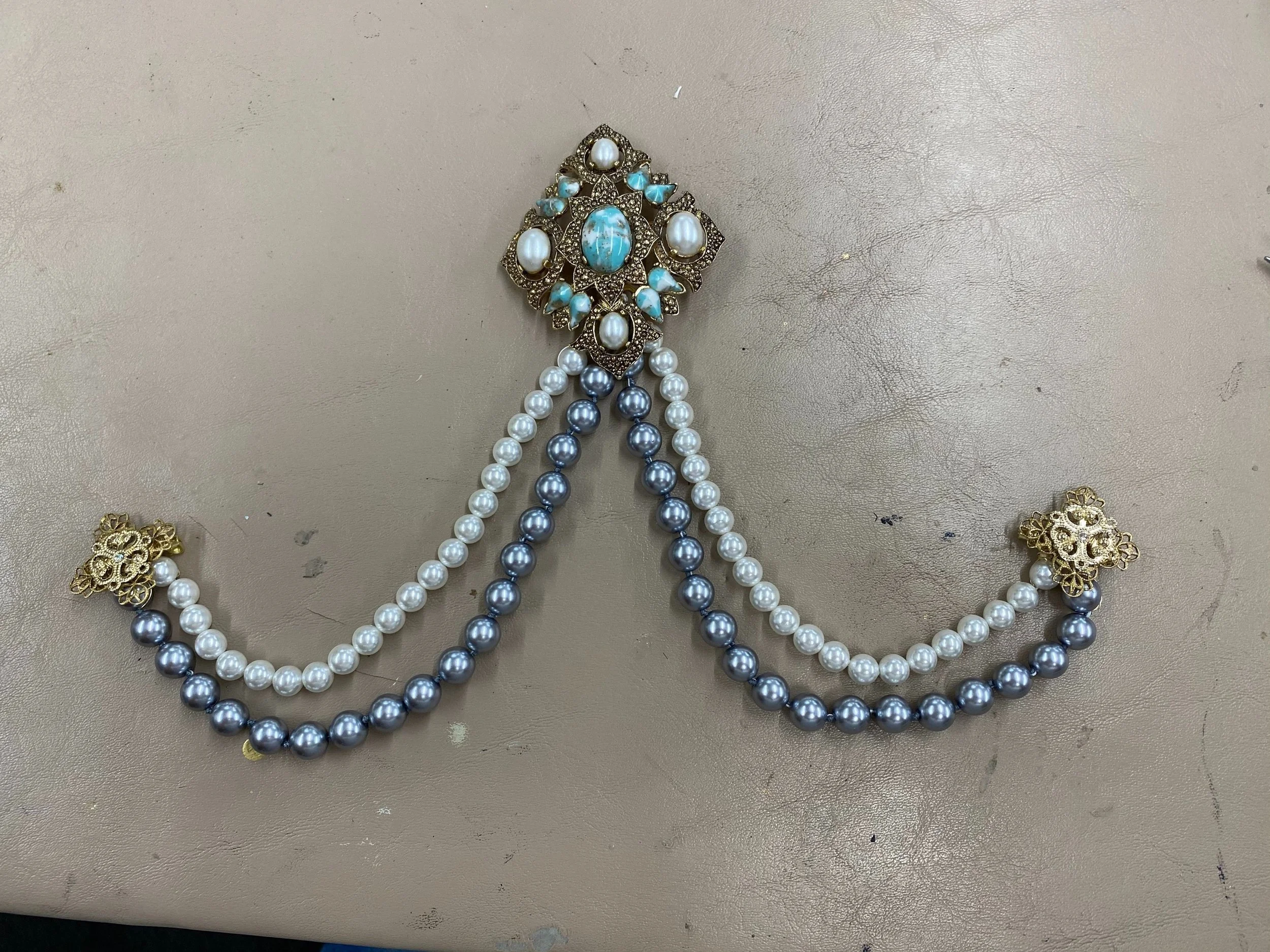 Created out of main middle broach, four smaller pendents and strings of pearls.