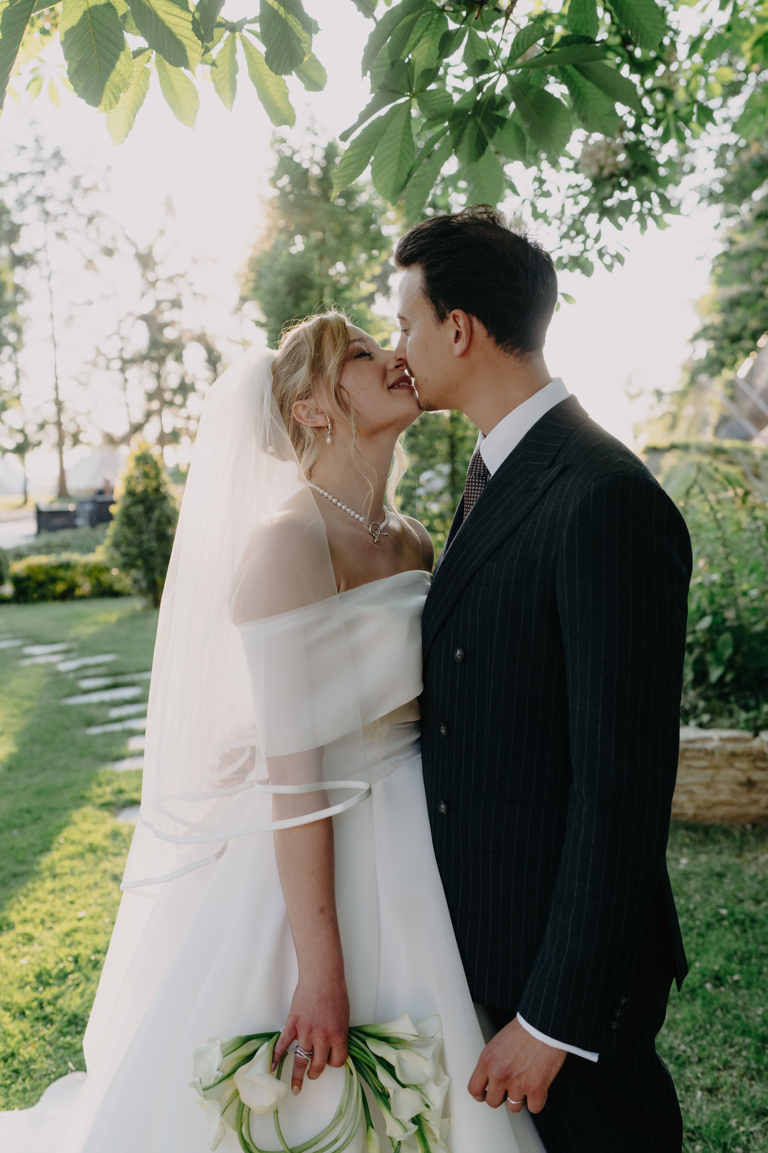 Estelle and Mehdi sharing a kiss in the garden, photographed by Julie Rivière