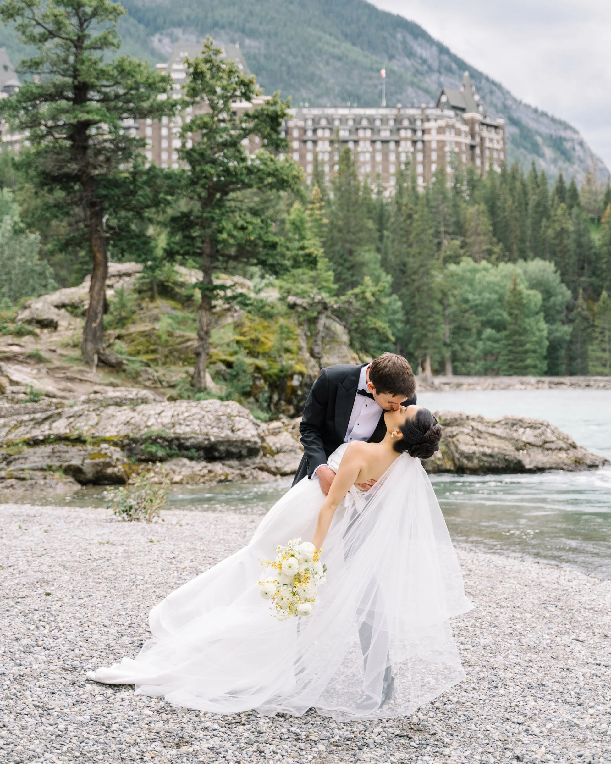 Summer wedding in Banff with bride and groom and Fairmont Banff Springs hotel in background